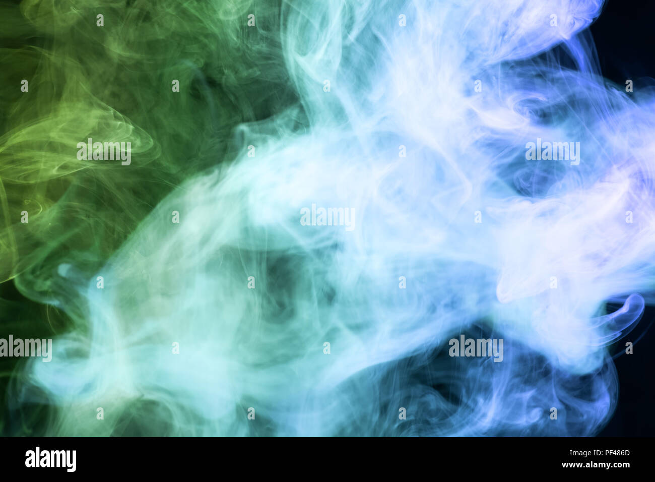 Blue and green cloud smoke on black isolated background Stock Photo - Alamy