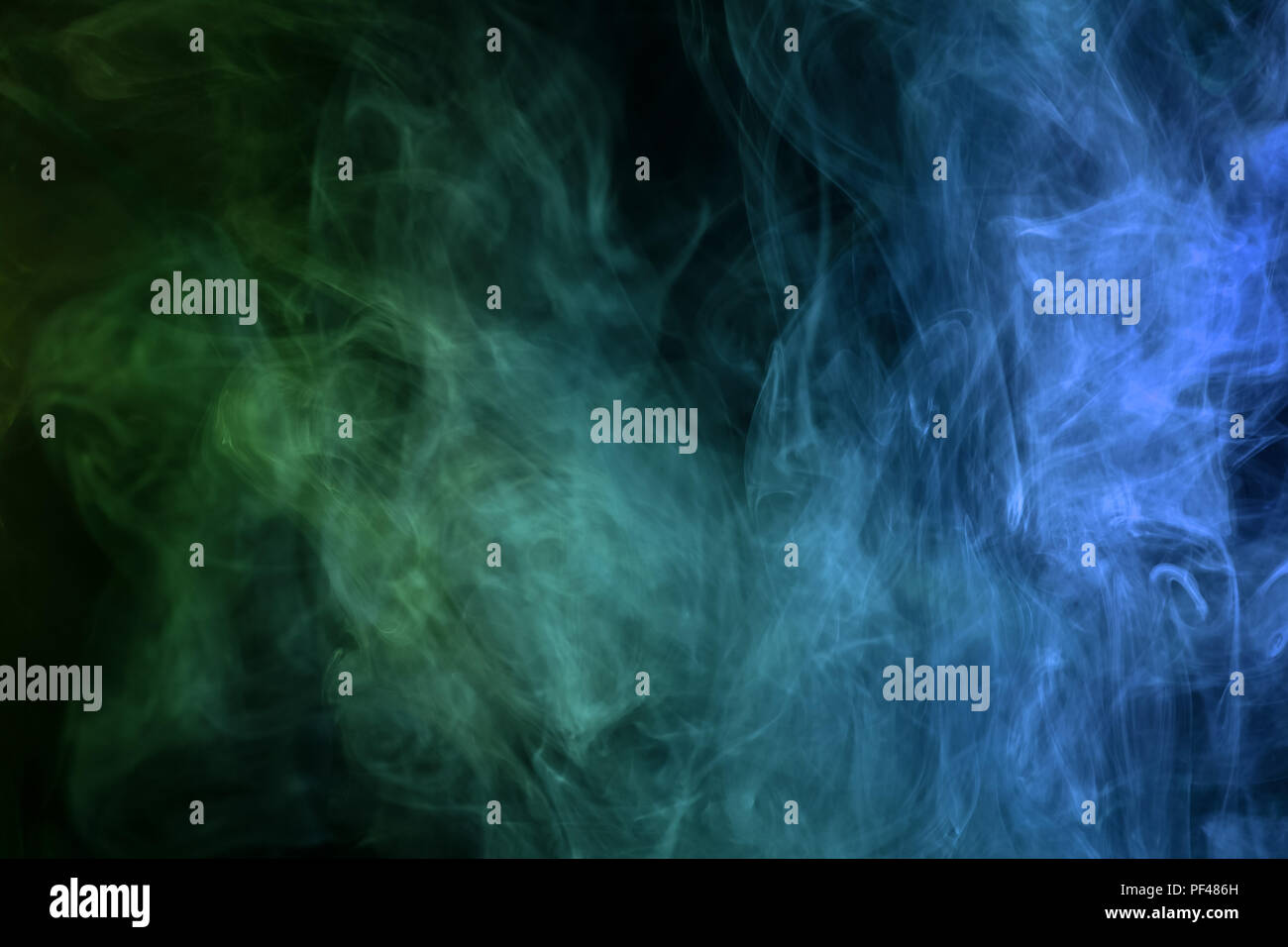 Blue and green cloud smoke on black isolated background Stock Photo - Alamy