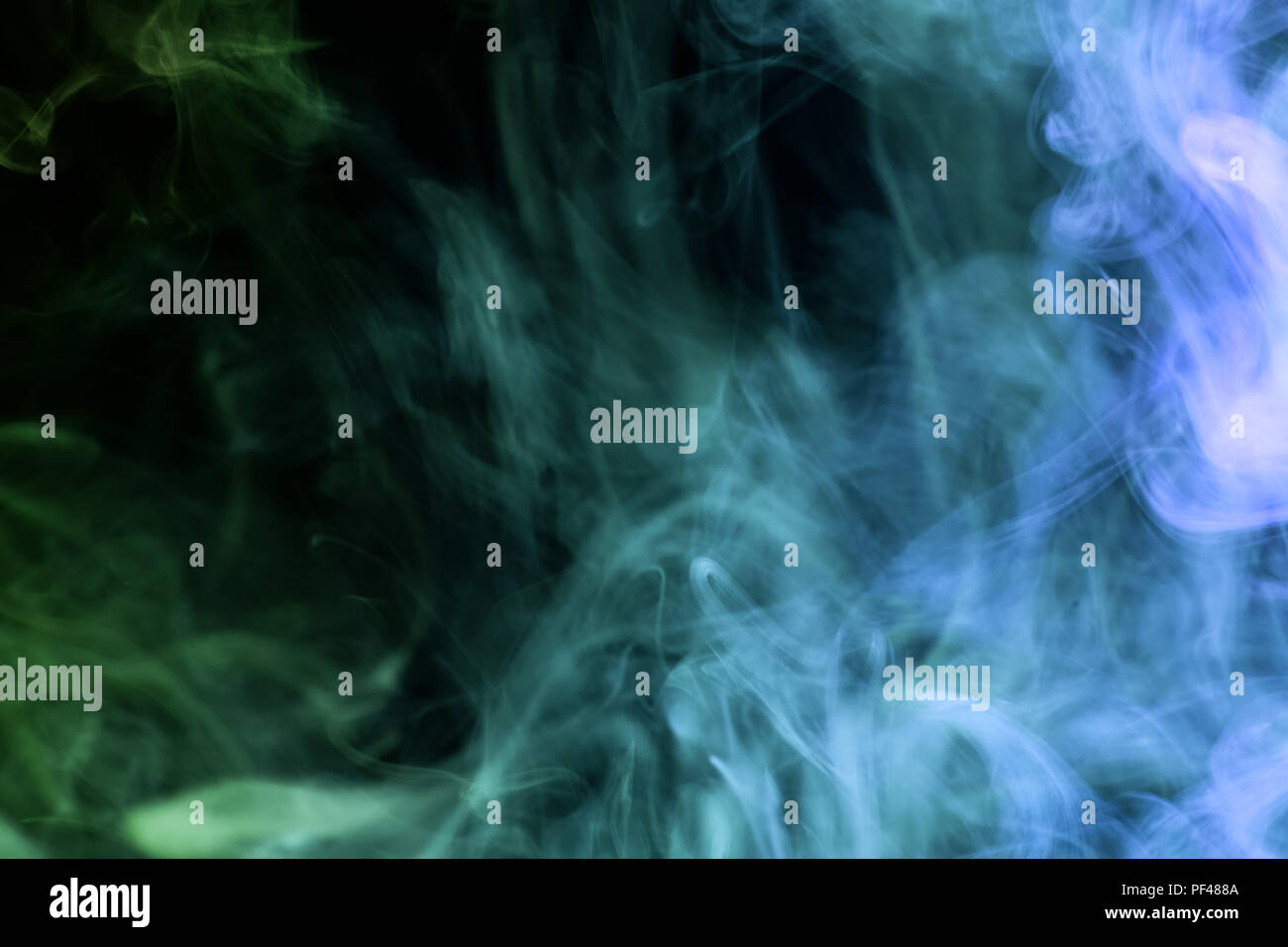 Blue and green cloud smoke on black isolated background Stock Photo - Alamy