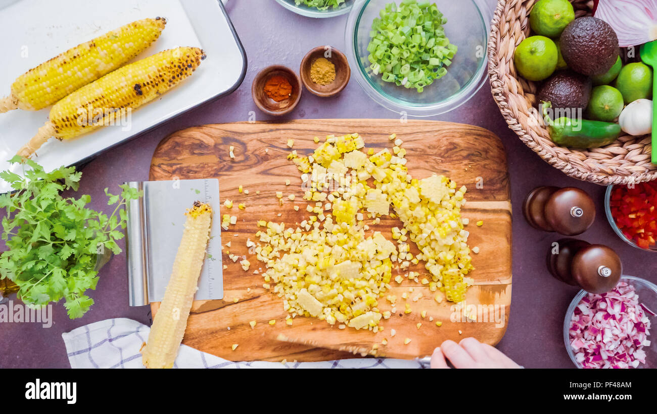 Step by step. Cutting the grilled corn of the cob ona wood cutting board Stock Photo Alamy