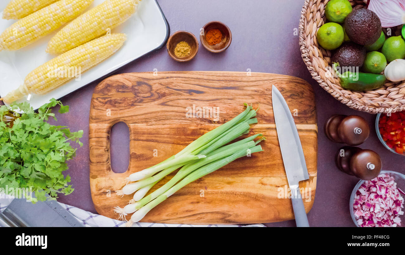 Step by step. Slicing green onions on a wood cutting board Stock Photo