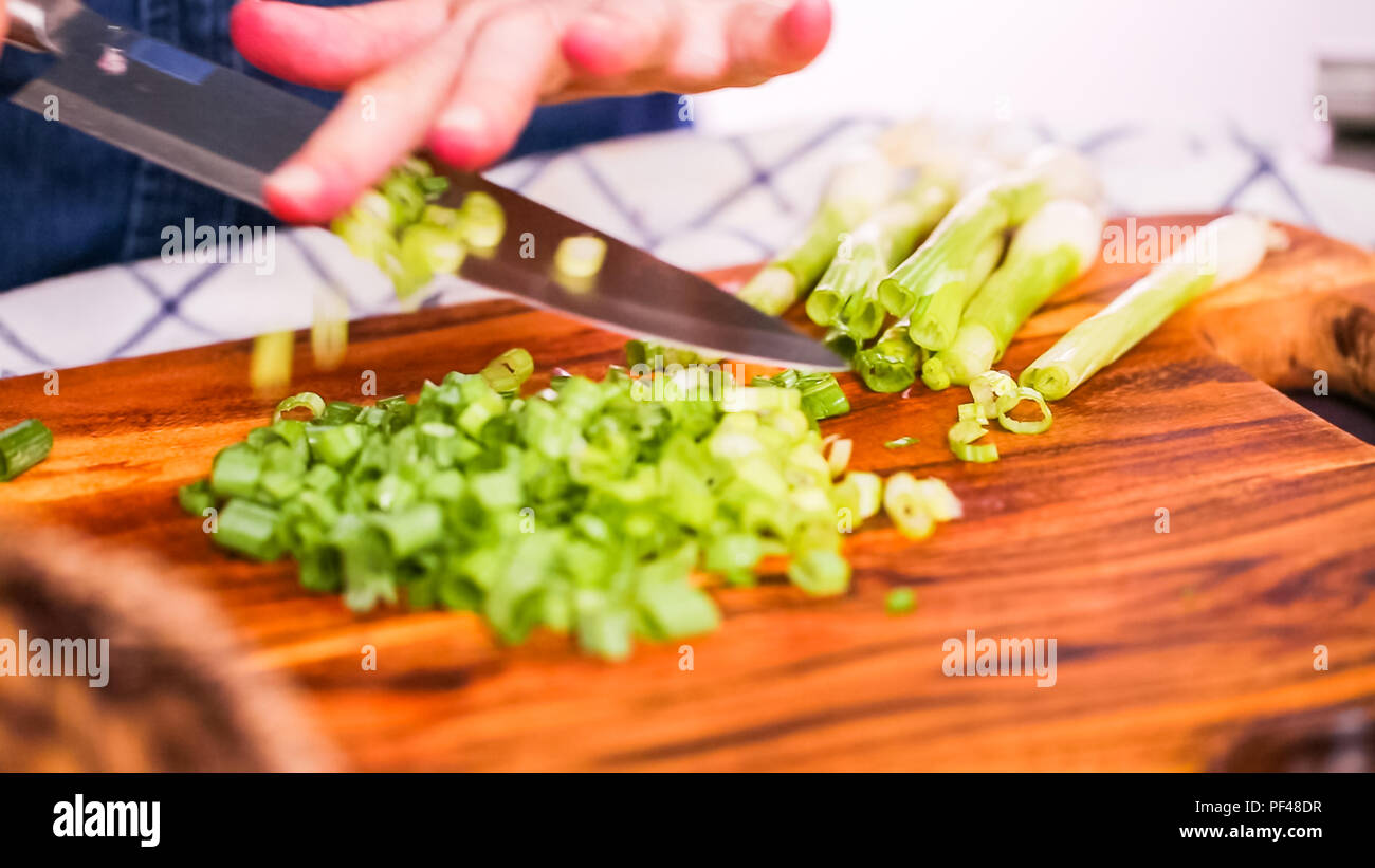 Step by step. Slicing green onions on a wood cutting board Stock Photo ...