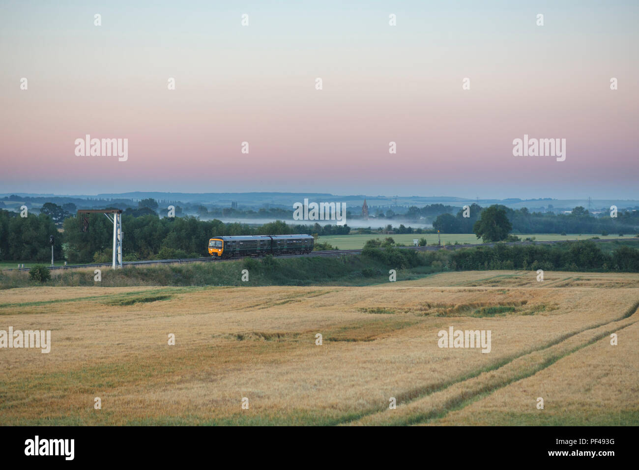 A First Great Western Railway class 165 Turbo train passing Culham at sunrise on a misty summer morning Stock Photo