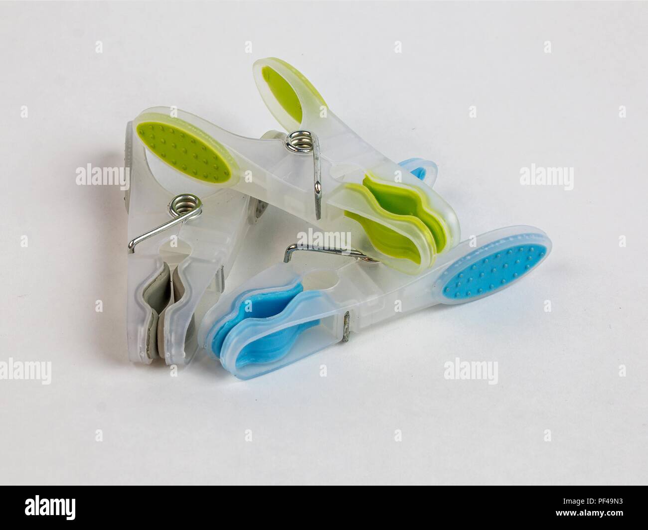 Plastic colorful clothes line pegs on white background Stock Photo