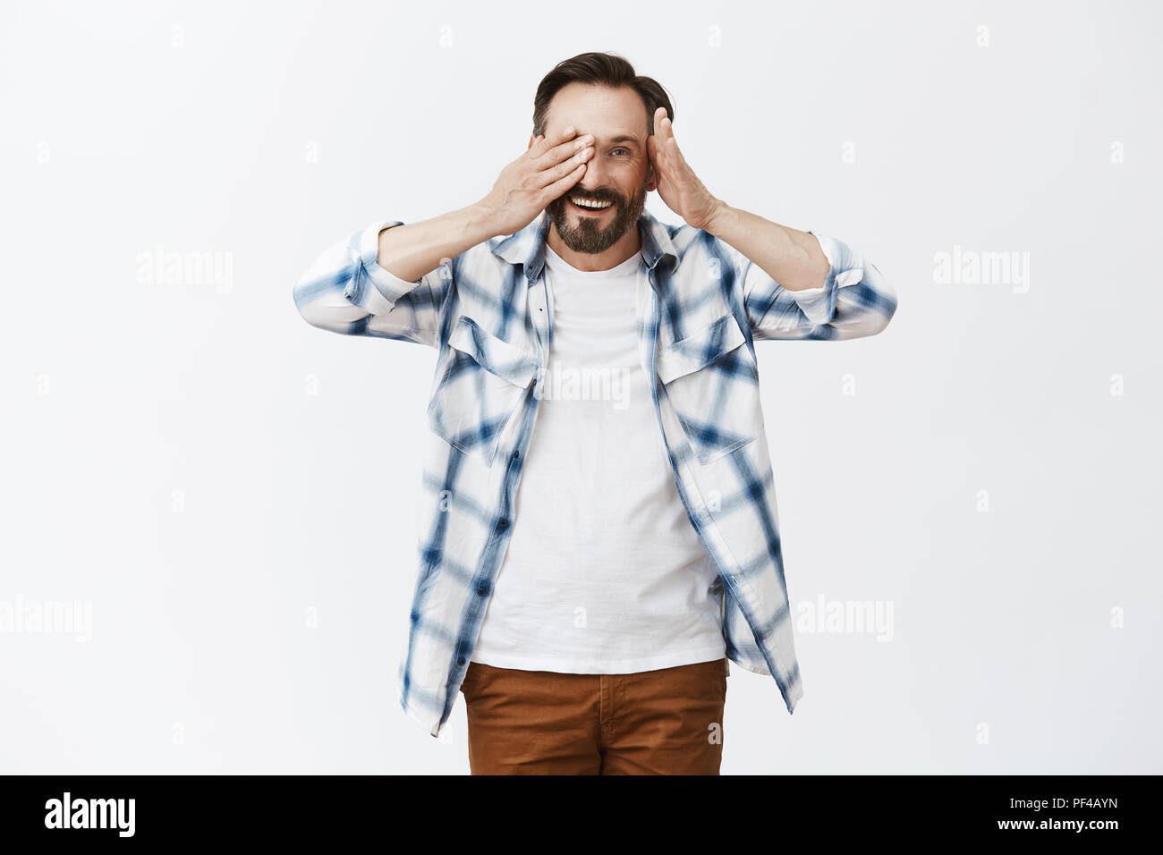 mature cutie Peek-a-boo cutie. Portrait of friendly and kind handsome mature male with  beard, taking off
