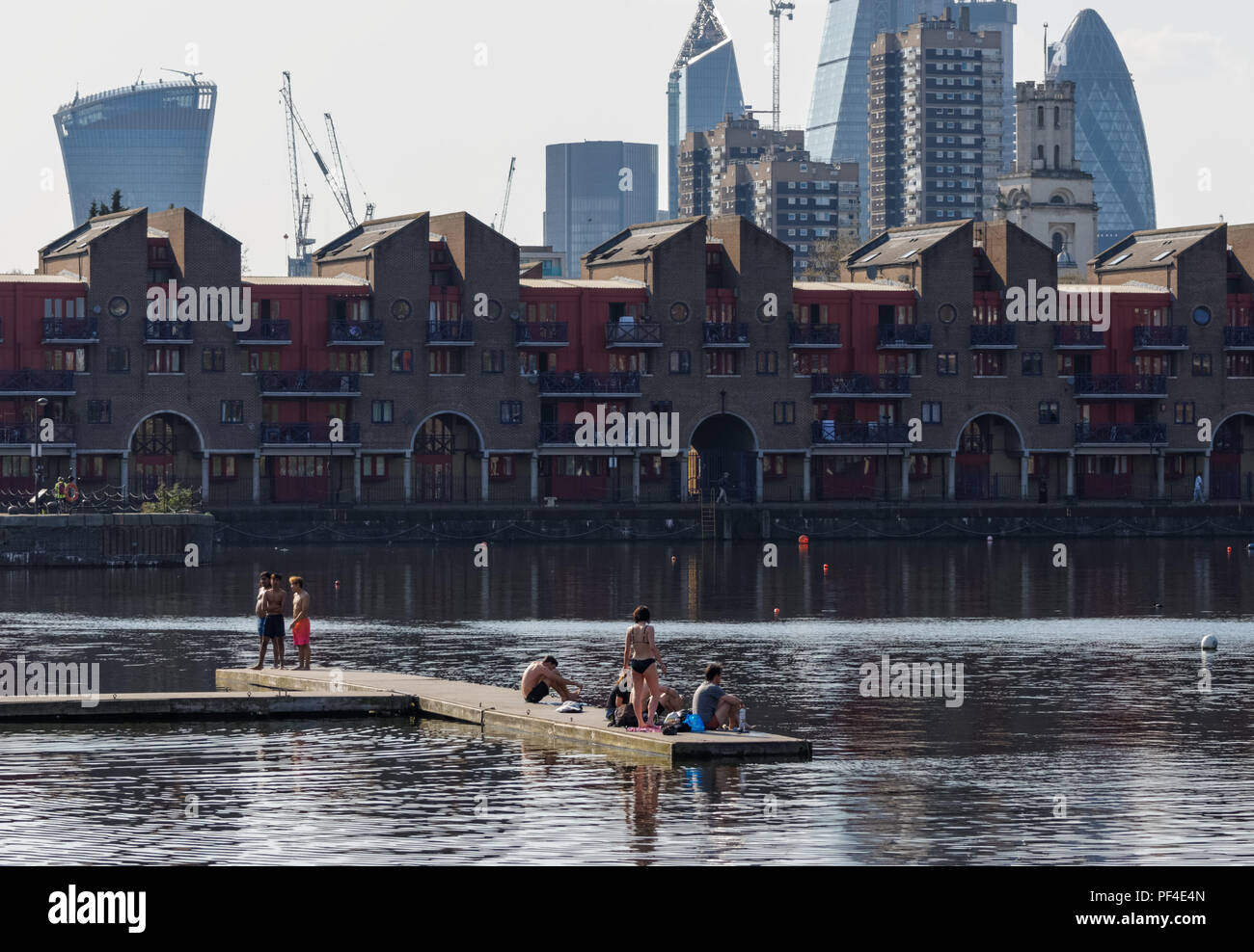 Residential buildings at Shadwell Basin with the city of London skyscrapers in the background, England United Kingdom UK Stock Photo