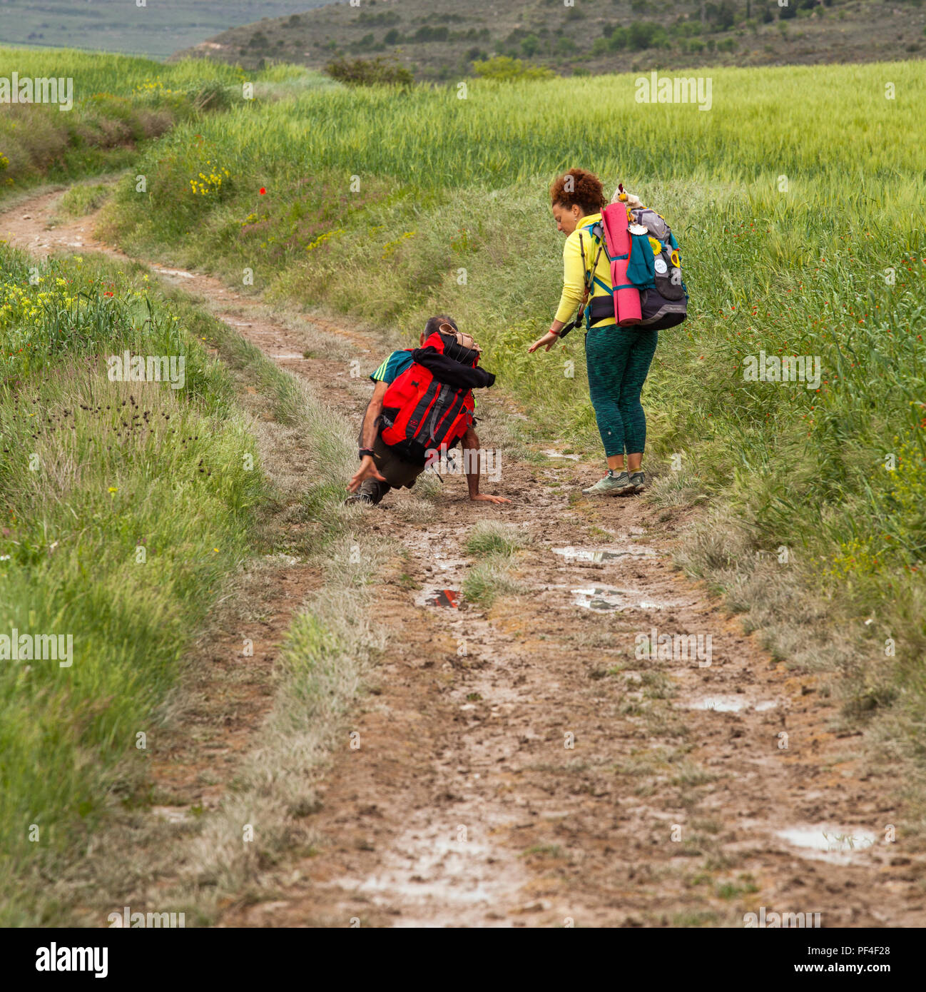 Pilgrim slipped fell over in mud while walking the Spanish Camino de Santiago the way of St James pilgrimage route Spain Stock Photo