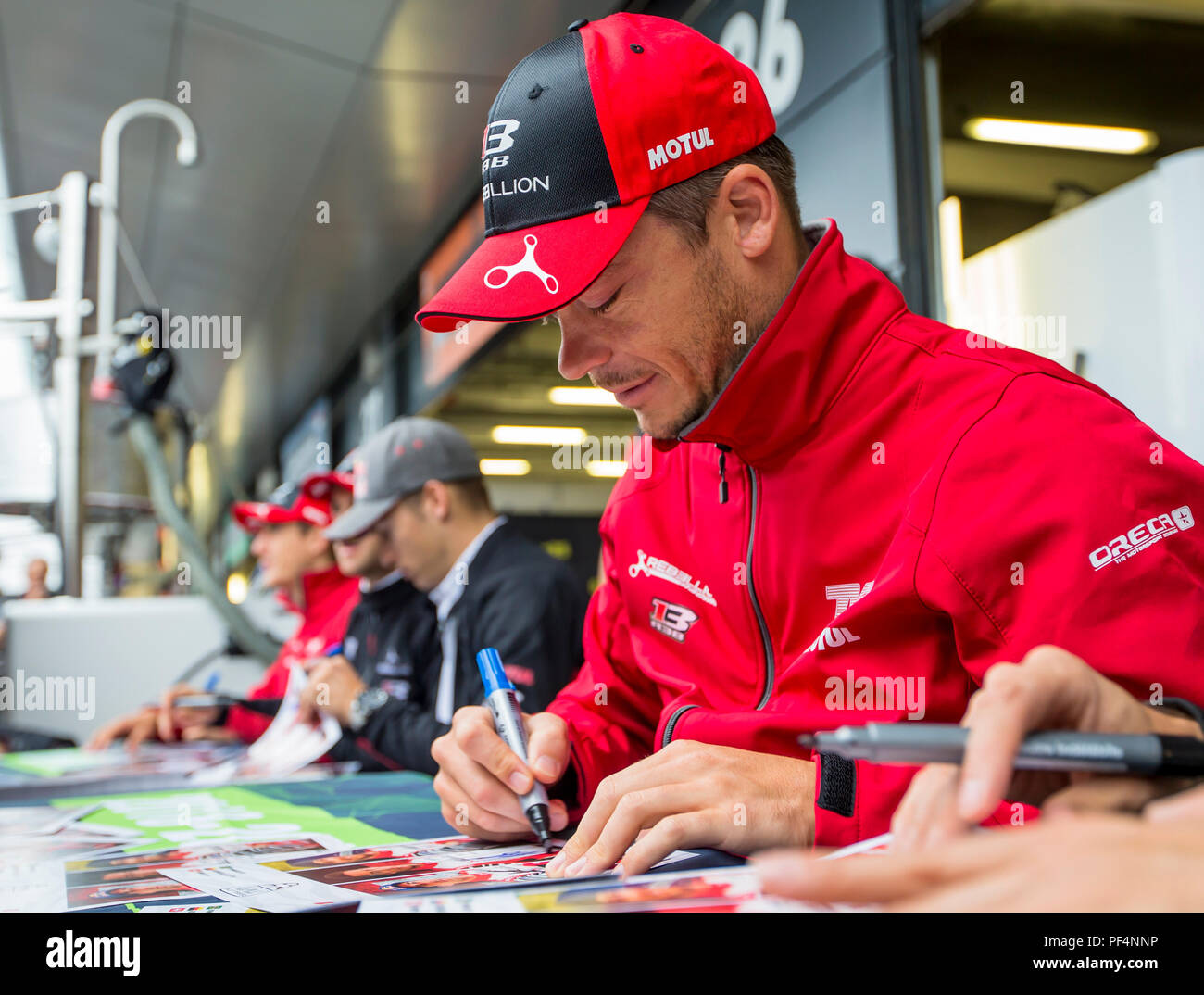 Silverstone Circuit, UK. 19th Aug, 2018. FIA World Endurance Championship; Andre Lotterer (DEU) of the Rebellion R13 Gibson LMP1 racing car from Rebellion Racing (CHE) signing spectator autographs outside the pit garage during Round 3 of the FIA World Endurance Championship at Silverstone Credit: Action Plus Sports/Alamy Live News Stock Photo