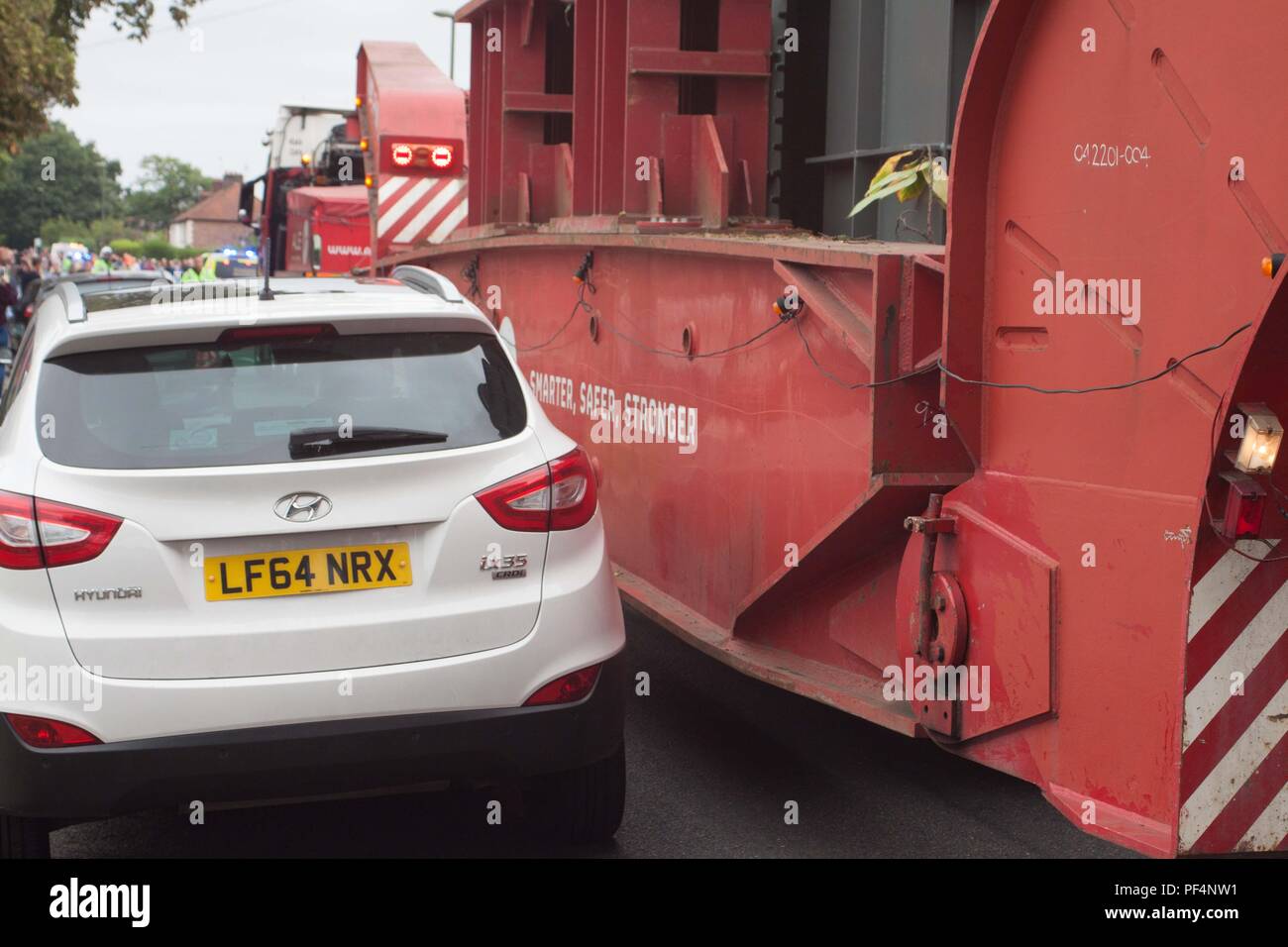 Surrey, UK. 19 August 2018.  68m long lorry carrying a electrical transformer navigates the narrow streets of Surrey. Credit: Andrew Spiers/Alamy Live News Stock Photo