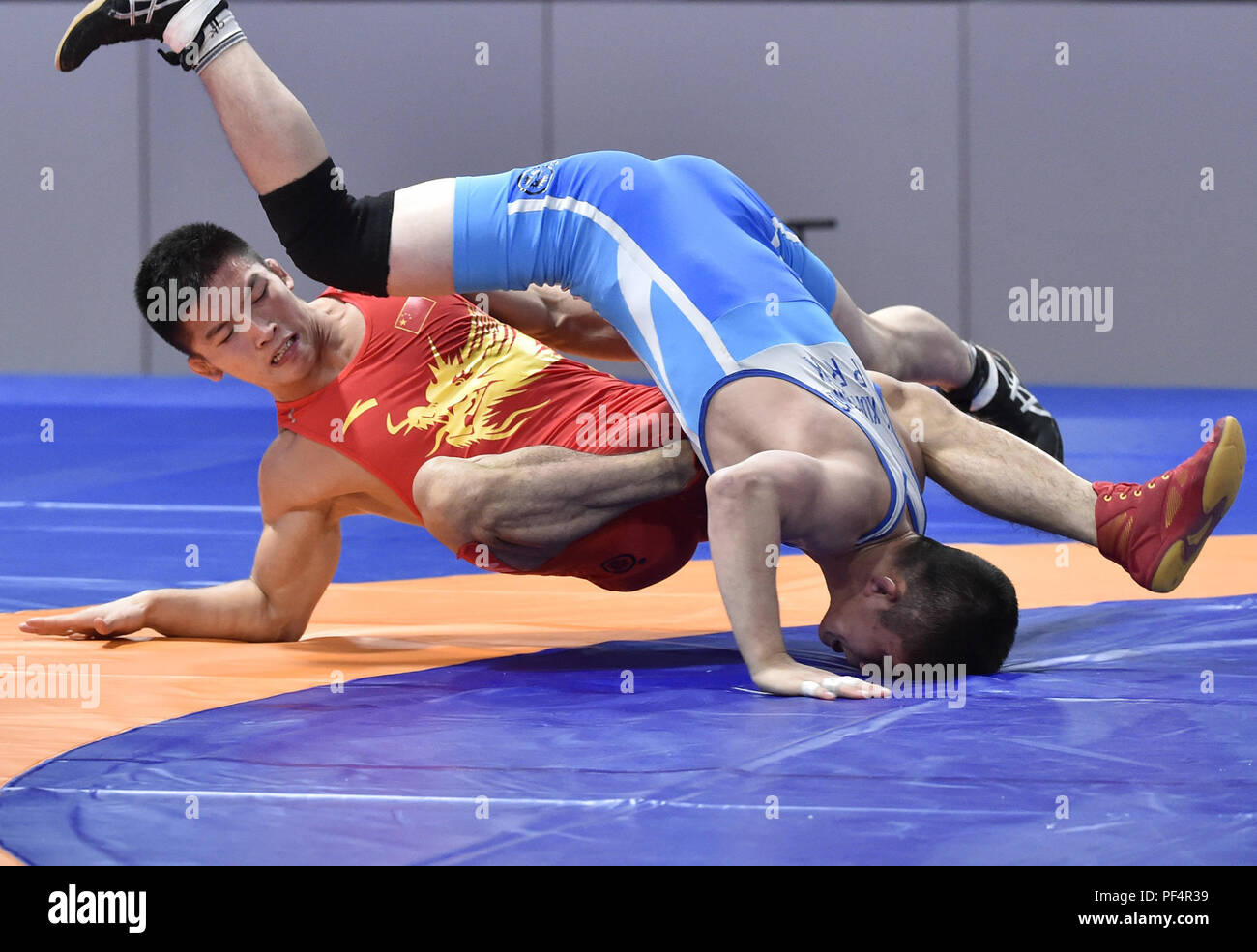 Jakarta, Indonesia. 19th Aug, 2018. Liu Minghu (L) of China competes during the Men's Freestyle 57kg Semifinals with Kang Kum Song of the Democratic People's Republic of Korea (DPRK) at the 18th Asian Games in Jakarta, Indonesia, Aug. 19, 2018. Credit: Li He/Xinhua/Alamy Live News Stock Photo