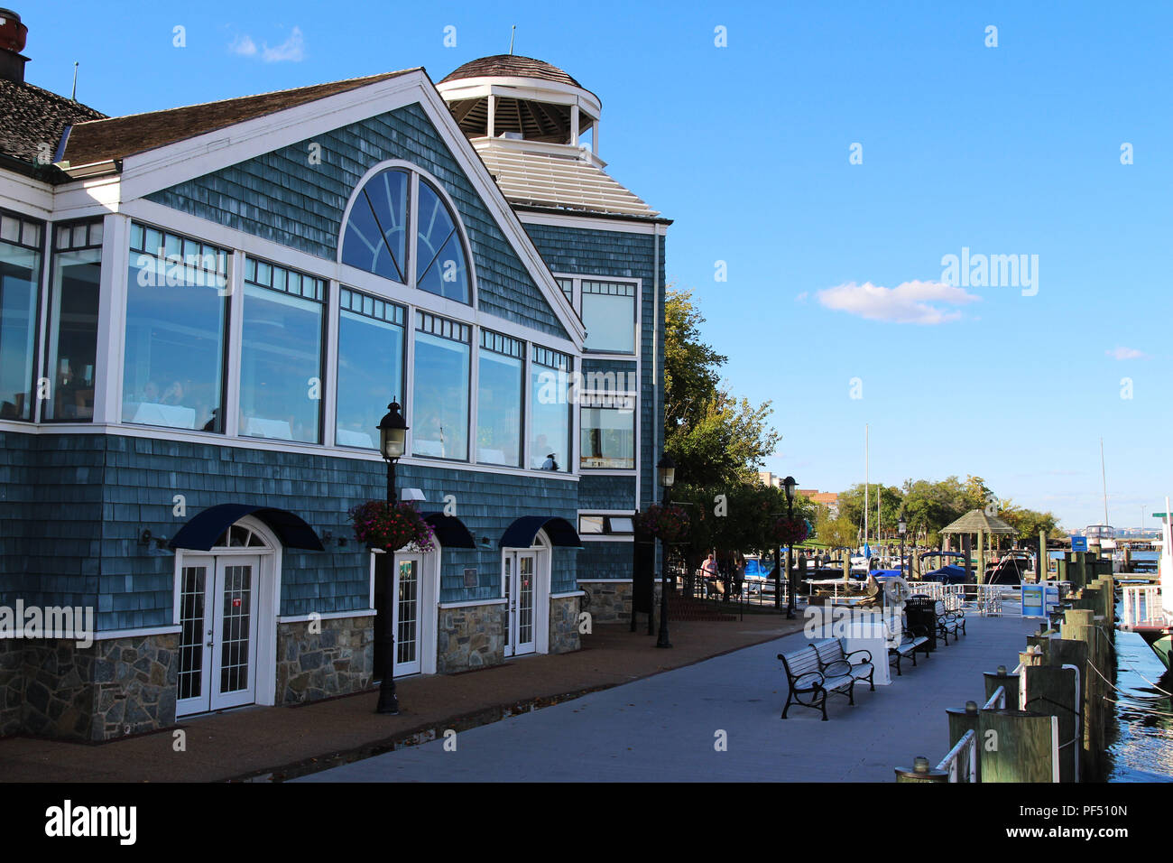 A historic building and boardwalk along the Potomac River waterfront, Old Town Alexandria, Virginia Stock Photo