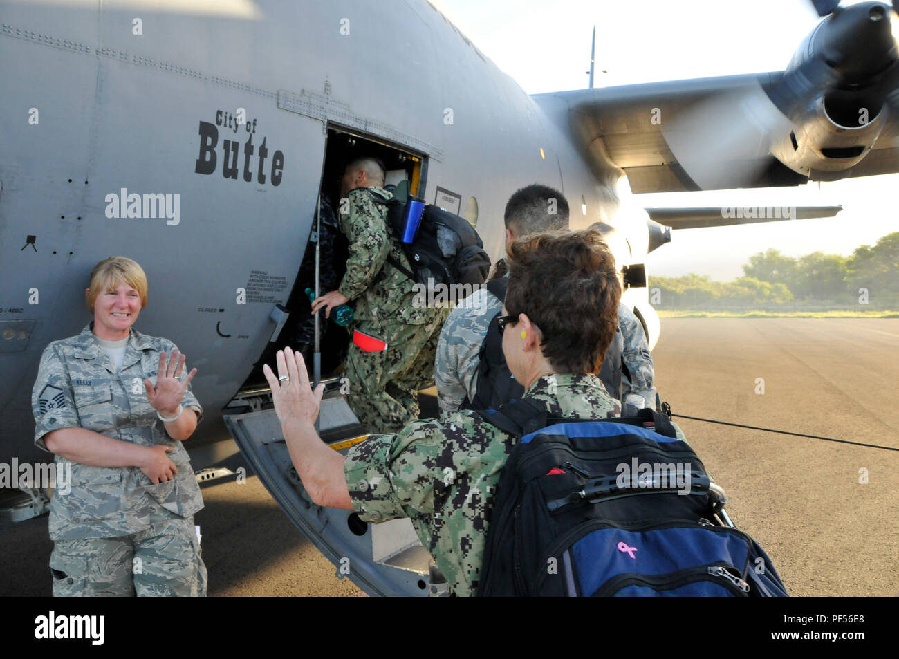 As the last few service members from the U.S. Air Force and Navy Reserve board a C-130 Hercules, a farewell is exchanged between U.S. Air Force Master Sgt. Michelle Kelly(left), an airlift manager assigned to the 173 Fighter Wing, Oregon National Guard and Navy Reserve Chief Petty Officer Deborah Hutchinson(right), a hospital corpsman assigned to the U.S. Navy Reserve before departing to Molokai, Hawaii for Tropic Care Maui County 2018, Aug. 10, 2018. Tropic Care Maui County 2018 is a joint-service, “hands-on” readiness training mission offering no cost medical, dental, and vision services to  Stock Photo