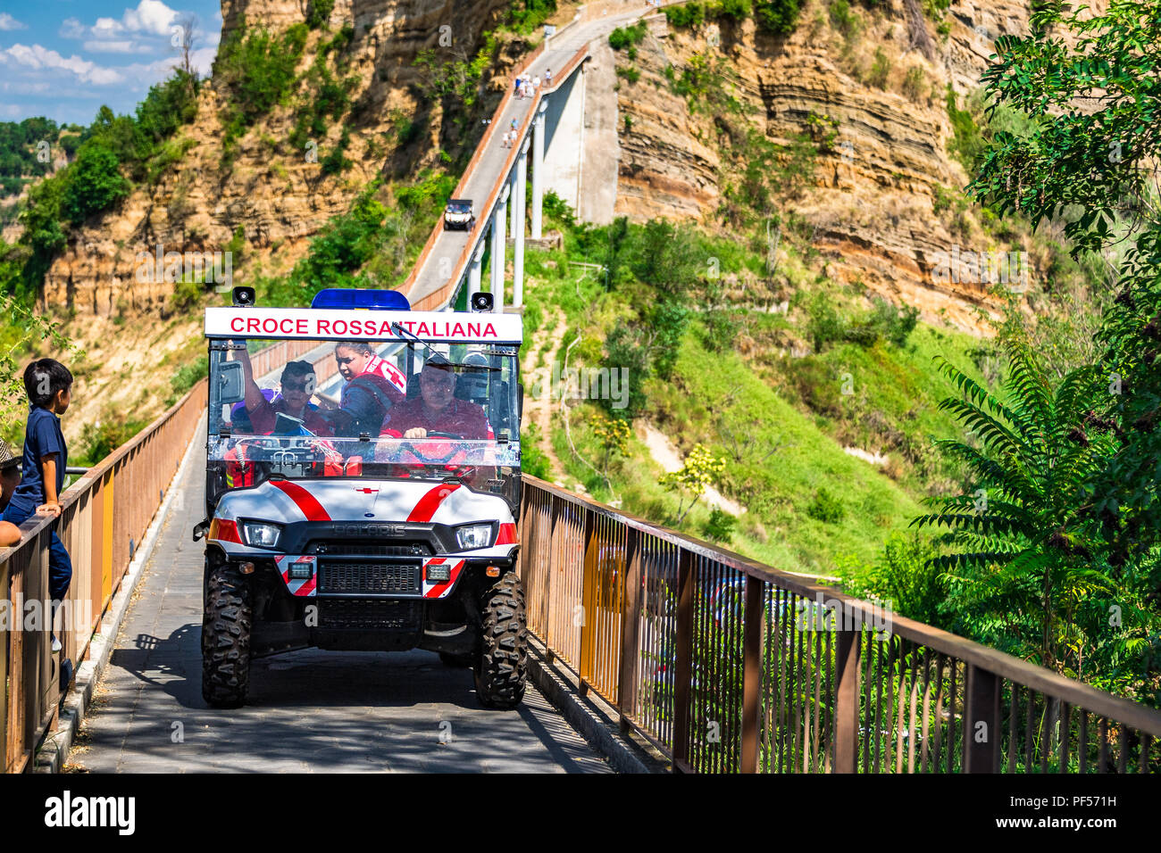 A specialised 4x4 ambulance evacuates a tourist with a medical emergency from Civita di Bagnoregio, across its famous bridge to a waiting ambulance. Stock Photo