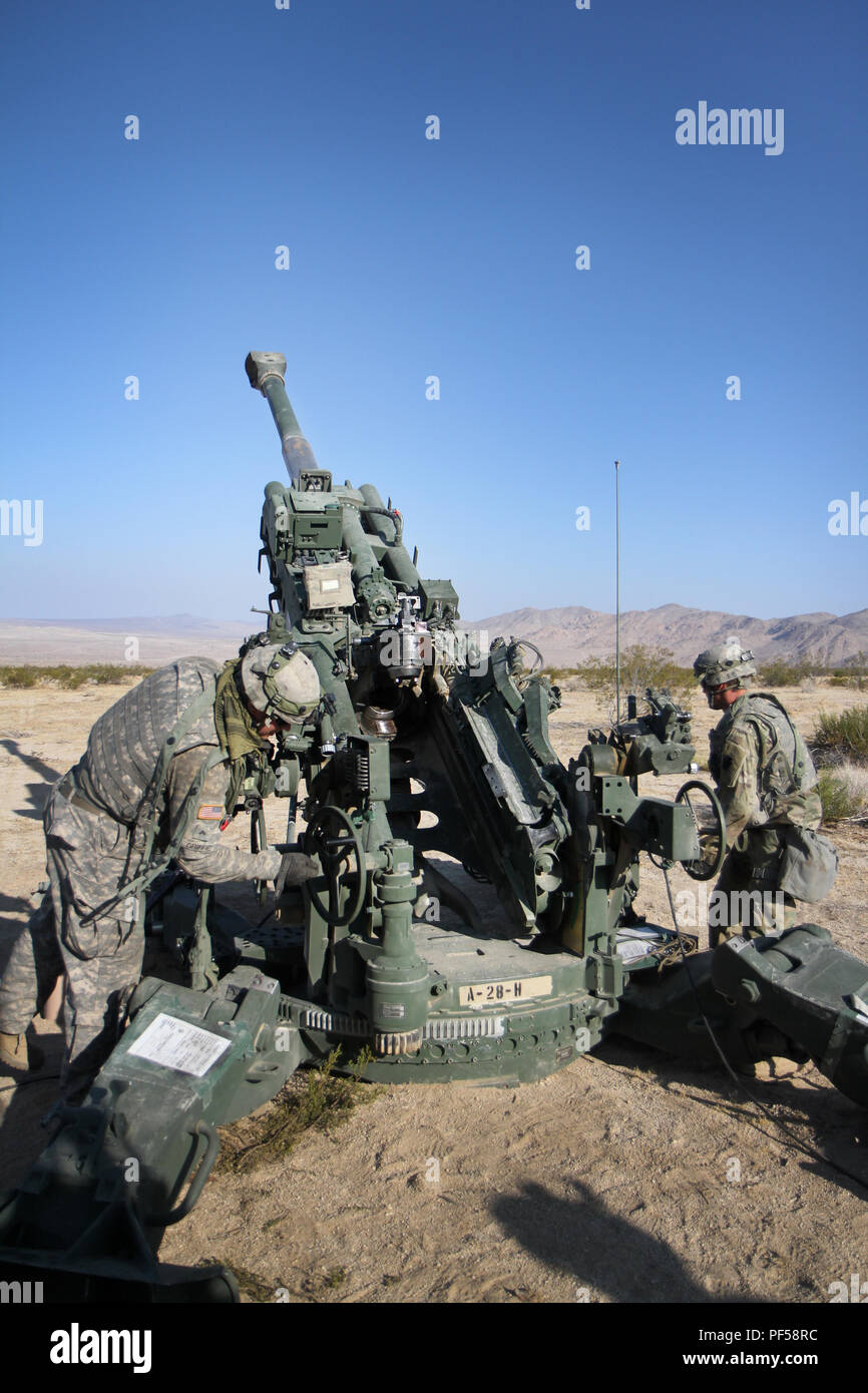 Cpl. Noah Griffie and Spc. Anthony Wiatrowski, canon crewmembers with the 1-108th Field Artillery Regiment, 56th Stryker Brigade Combat Team, 28th Infantry Division, Pennsylvania National Guard set the azimuth to fire their M777 Howitzer, at Fort Irwin, California. (U.S. Army National Guard photo by Cpl. Hannah Baker/released) Stock Photo