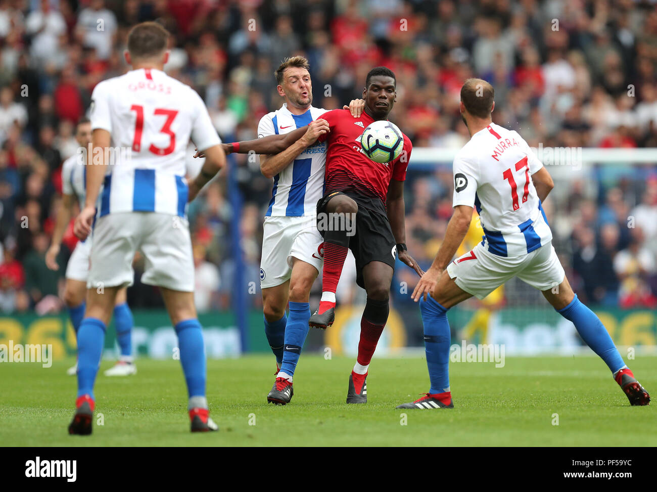 Manchester United's Paul Pogba (centre) battles for the ball with Brighton & Hove Albion's Dale Stephens (left) and Glenn Murray (right) during the Premier League match at the AMEX Stadium, Brighton. PRESS ASSOCIATION Photo. Picture date: Sunday August 19, 2018. See PA story SOCCER Brighton. Photo credit should read: Gareth Fuller/PA Wire. RESTRICTIONS: No use with unauthorised audio, video, data, fixture lists, club/league logos or 'live' services. Online in-match use limited to 120 images, no video emulation. No use in betting, games or single club/league/player publicatio Stock Photo