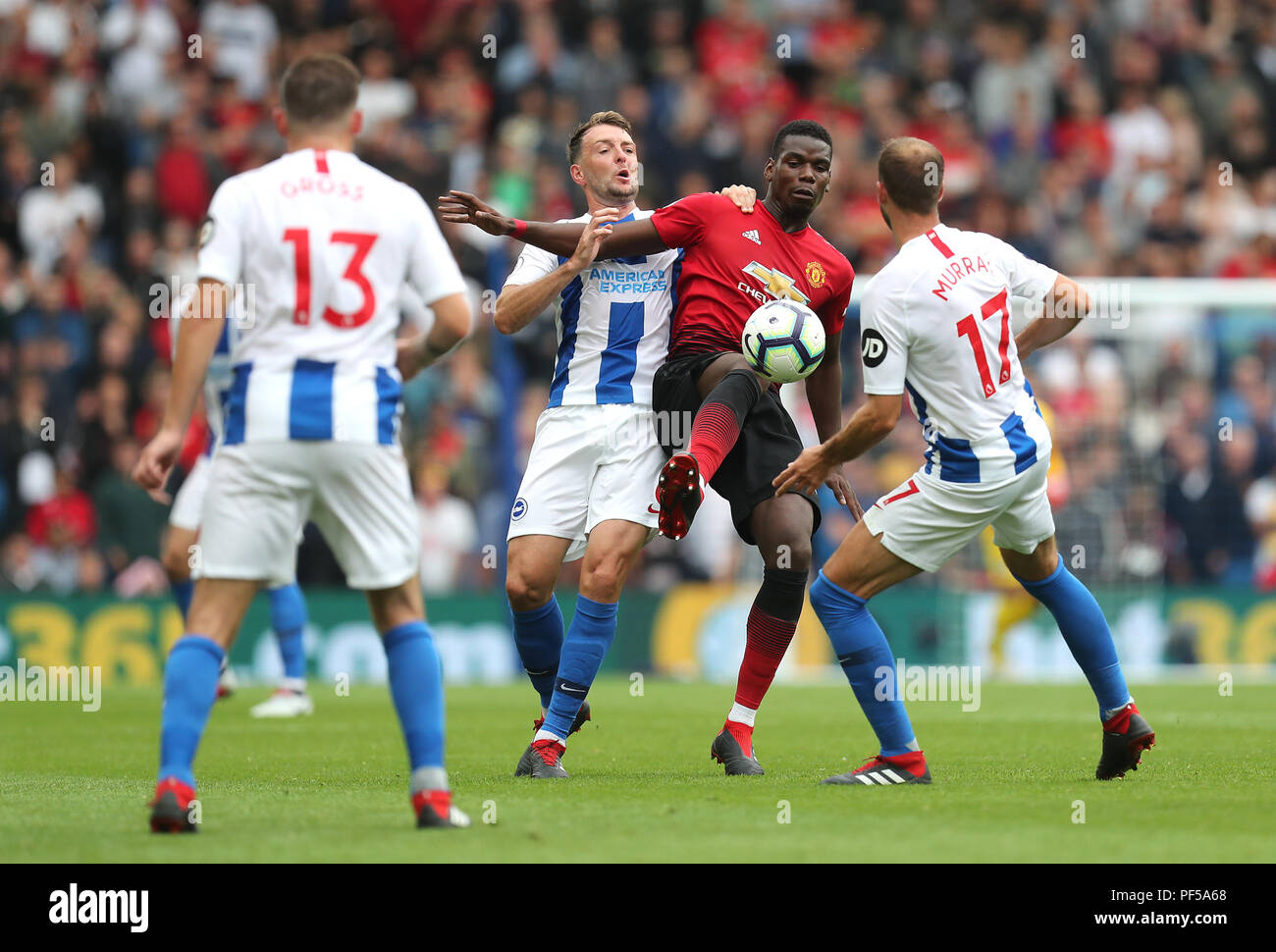 Manchester United's Paul Pogba (centre) battles for the ball with Brighton & Hove Albion's Dale Stephens (left) and Glenn Murray (right) during the Premier League match at the AMEX Stadium, Brighton. Stock Photo