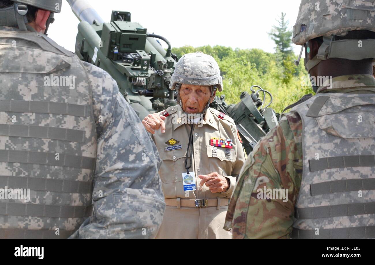 CAMP GRAYLING, Mich. - World War II veteran, Claude Cawood, talks with Rhode Island Army National Guard Soldiers from Battery A, 1st Battalion, 103rd Field Artillery Regiment, during a visit to the Northern Strike exercise on Aug. 9, 2018 at Camp Grayling, Mich. Cawood, a former section chief on the M105 Howitzer during his three years in the Philippines had an opportunity to visit Soldiers and fire an M777 Howitzer. (U.S. Army National Guard photo by 1st Sgt. Sara Robinson) Stock Photo