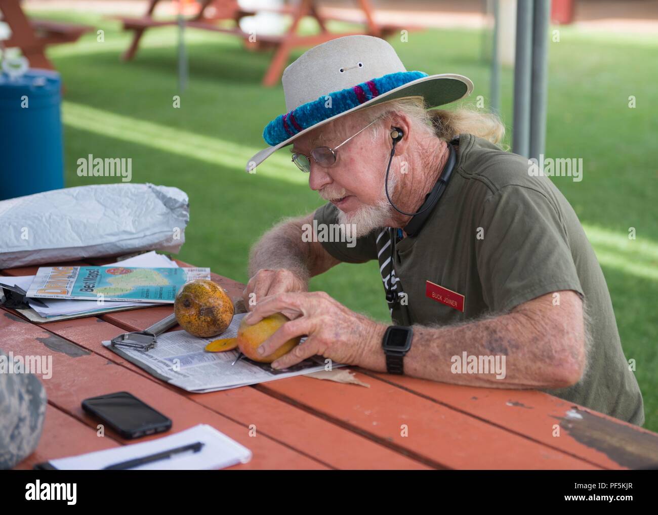 https://c8.alamy.com/comp/PF5KJR/local-volunteer-and-community-leader-buck-joiner-opens-a-mango-to-share-at-the-kihei-clinic-during-tropic-care-maui-county-2018-in-kihei-hawaii-aug-14-2018-tropic-care-maui-county-2018-is-a-joint-service-hands-on-readiness-training-mission-offering-no-cost-medical-dental-and-vision-services-to-people-at-six-locations-across-maui-molokai-and-lanai-from-august-11-19-us-air-national-guard-photo-by-tech-sgt-seth-bleuer-PF5KJR.jpg
