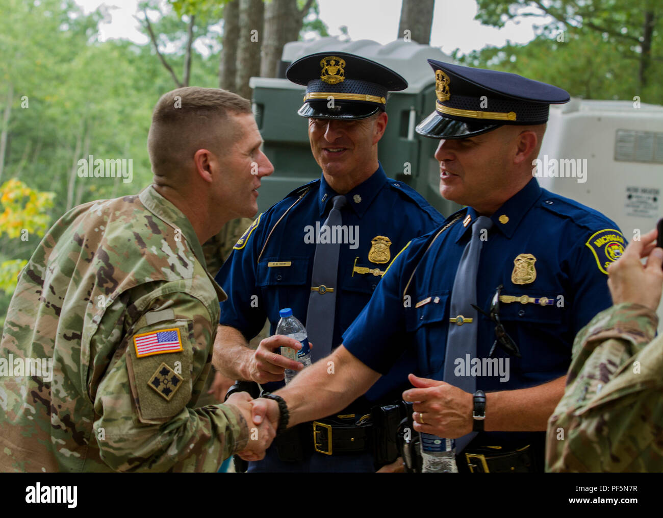 Sergeant Major of the Army Dan Dailey shakes hands with Michigan State Police Troopers prior to viewing a demonstration by the 126th Infantry Regiment at Camp Grayling, MI, August 15, 2018. SMA Dailey is visiting as part of Northern Strike 18, a National Guard Bureau-sponsored exercise uniting service members from many states, multiple service branches and a number of coalition countries during the first three weeks of August 2018 at the Camp Grayling Joint Maneuver Training Center and the Alpena Combat Readiness Training Center, both located in northern Michigan and operated by the Michigan N Stock Photo