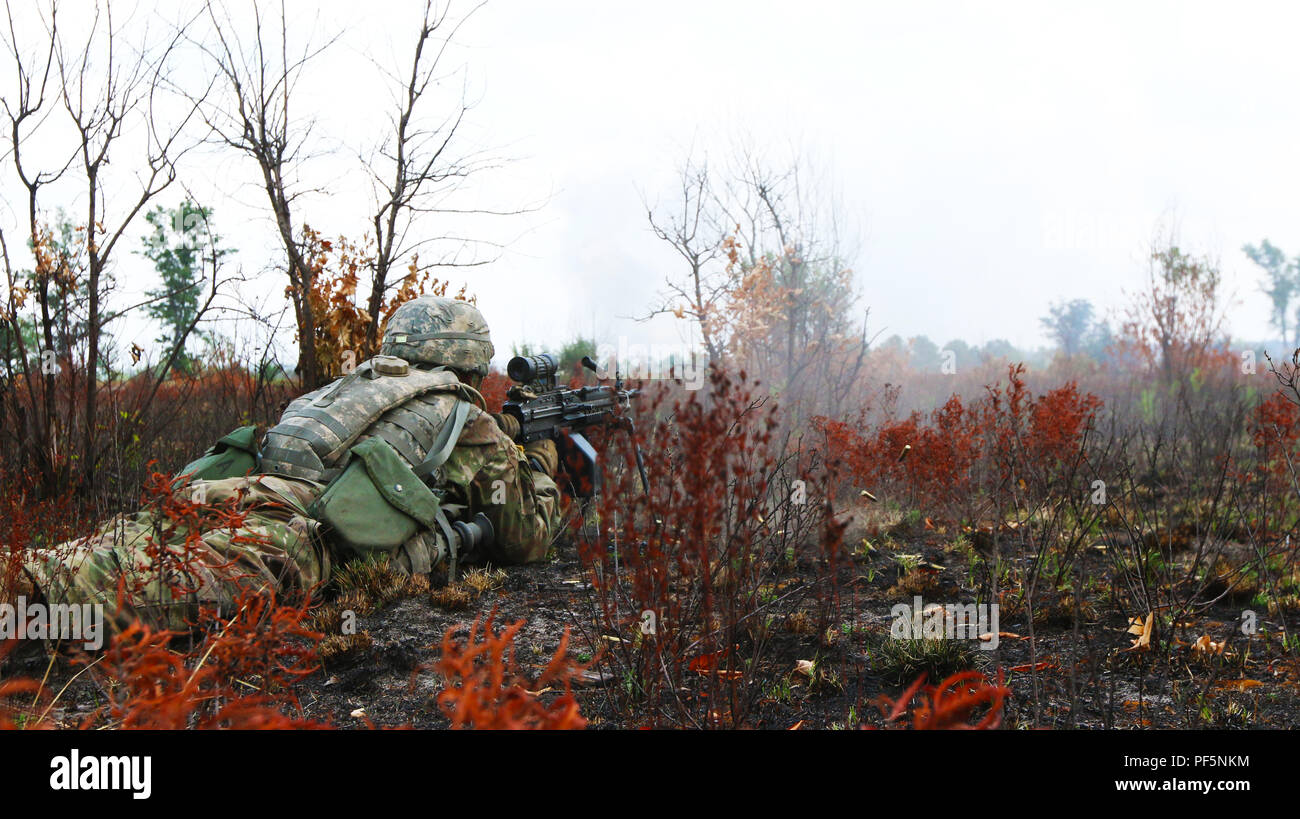 CAMP GRAYLING, Mich. – A Soldier from Company C, 3rd Battalion, 126th Infantry Regiment, Michigan Army National Guard, provides suppressive fire to support the company’s movement, during an assault on their objective during Northern Strike at Camp Grayling, Mich., on August 15, 2018. (U.S. Army photo by Spc. Tyler Morford) Stock Photo