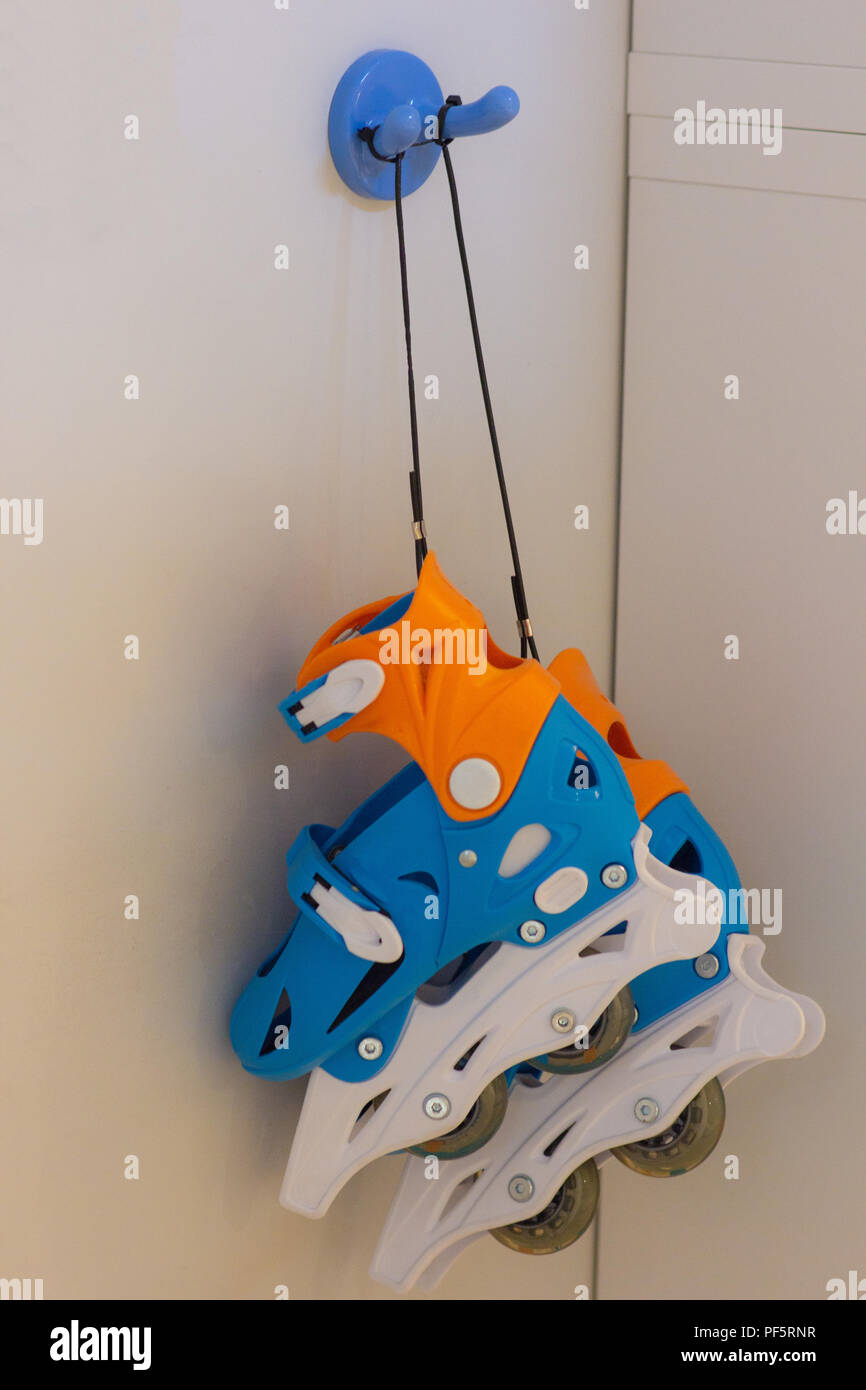 Roller skates hanging on a blue hook Stock Photo Alamy
