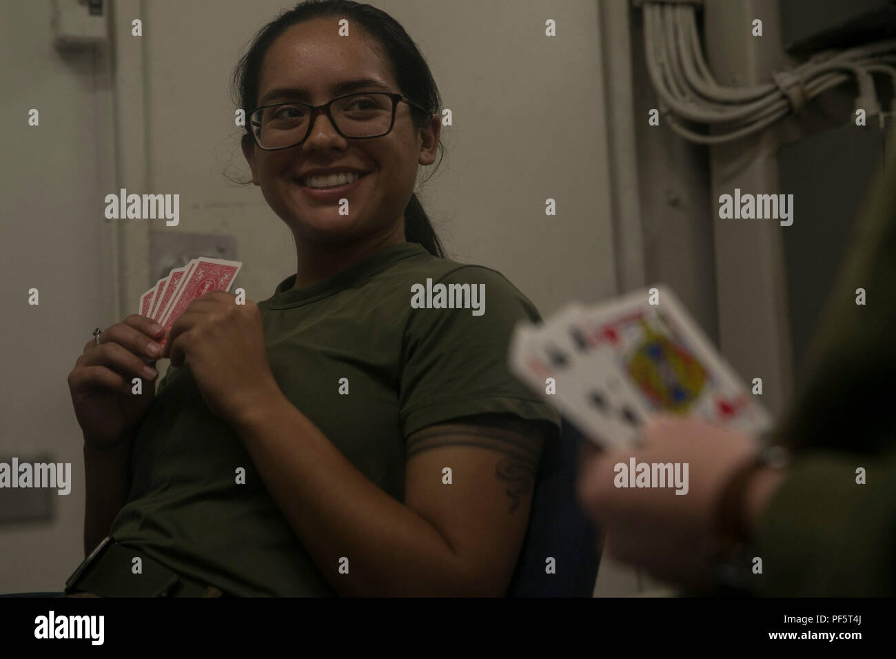 Lance Cpl. Savannah R. Lucero, a crypto linguist with the 31st Marine  Expeditionary Unit, plays a game of go-fish in the female berthing aboard  the USS Wasp (LHD-1) at White Beach Naval