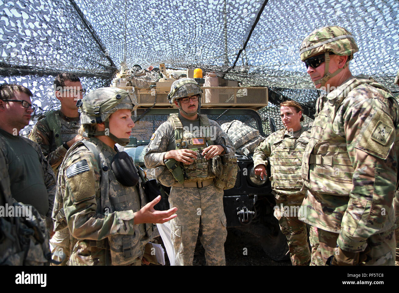 Lt. Gen. Timothy J. Kadavy, Director of the Army National Guard, engages with Soldiers of the 112th Infantry Battalion, 56th Stryker Brigade Combat Team, 28th Infantry Division, Pennsylvania Army National Guard Aug. 16. Kadavy held an informal after action review of the troops’ experiences at the National Training Center, Fort Irwin, Calif. and recognized Soldiers who surpassed their leaders’ expectations. 2nd Lt. Mia Casale, a Soldier with the 2-112th Infantry Battalion, received a coin from Kadavy for her exemplary skill and performance during her NTC rotation. (U.S. Army National Guard phot Stock Photo