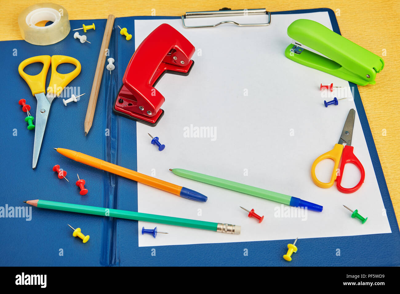 Assorted stationery above clipboard file folder and blank white paper ...