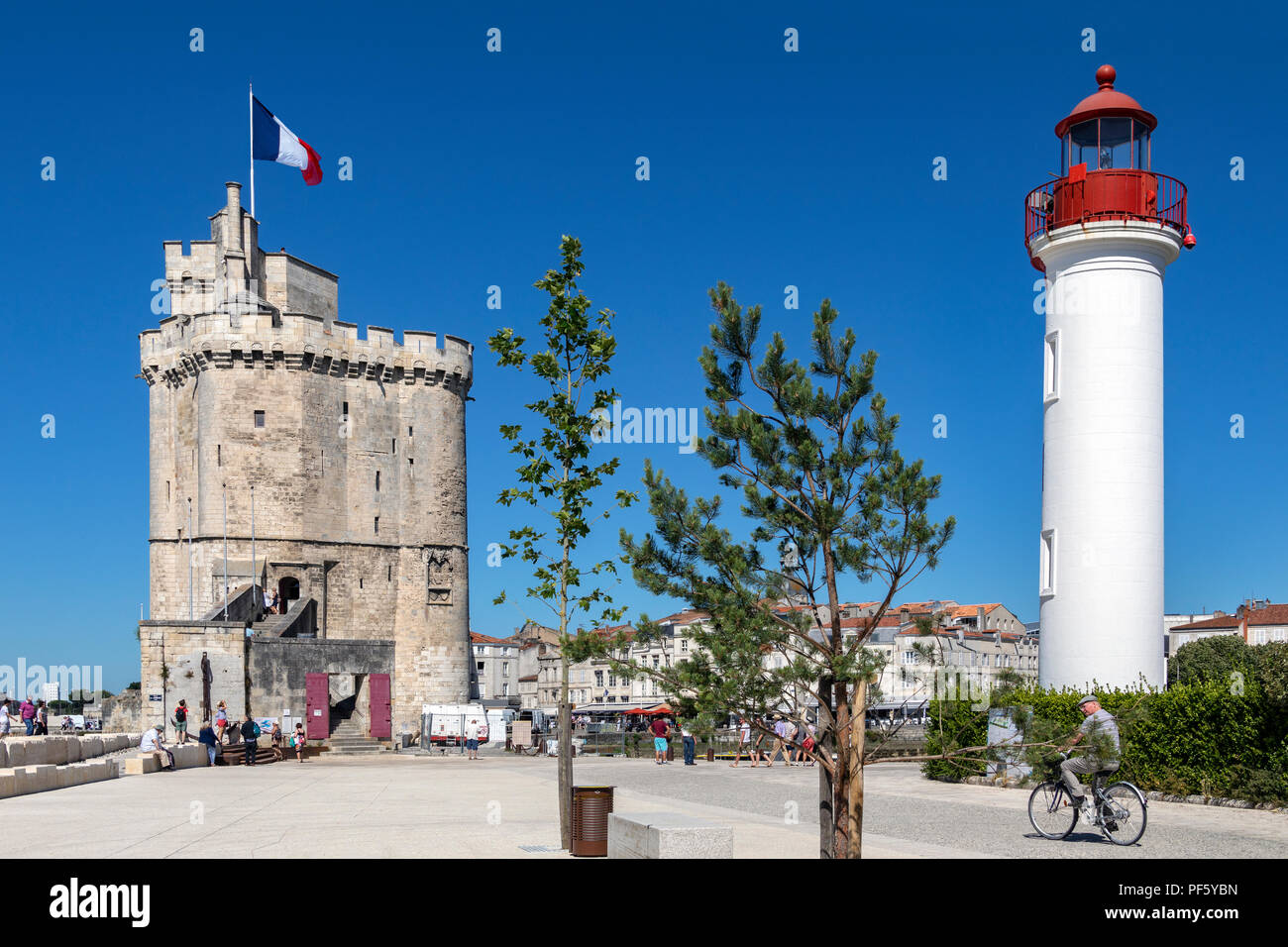 Lighthouse in the port of La Rochelle on the coast of the Poitou-Charentes region of France. The tower with the flag is the Tour de la Chaine which da Stock Photo