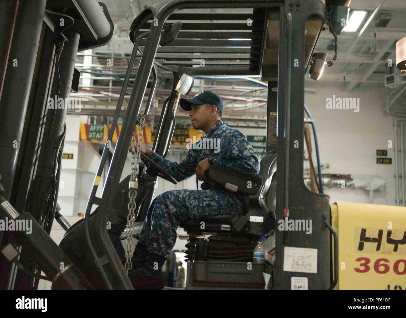 180814-N-MY760-093   PORTSMOUTH, Va. (Aug. 14, 2018) Aviation Boatswain's Mate (Handling) 3rd Class Theepan Perampalam, from Sinajama, Guam, operates a forklift aboard the aircraft carrier USS Dwight D. Eisenhower (CVN 69)(Ike). Ike is undergoing a Planned Incremental Availability (PIA) at Norfolk Naval Shipyard during the maintenance phase of the Optimized Fleet Response Plan (OFRP). (U.S. Navy photo by Mass Communication Specialist Seaman Apprentice Tyler Miller) Stock Photo
