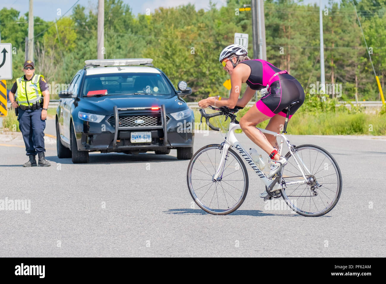 Adult female competes in the cycling leg of the Orillia Triathlon.  The event is very popular and includes races geared to all ages and skill levels. Stock Photo