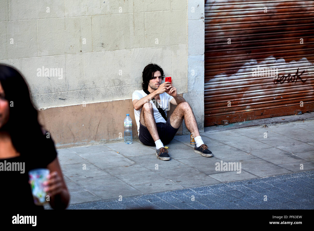 Young man using his smartphone, Gracia, Barcelona. Stock Photo
