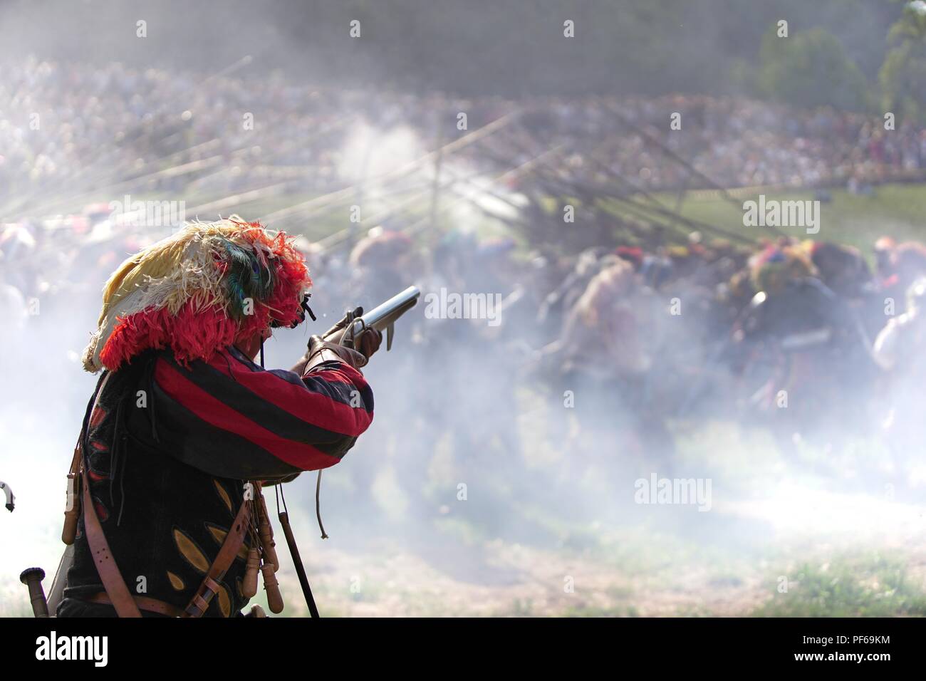 Lansquenet mercenary aiming a flintlock gun in the smoke on the historic battlefield Stock Photo