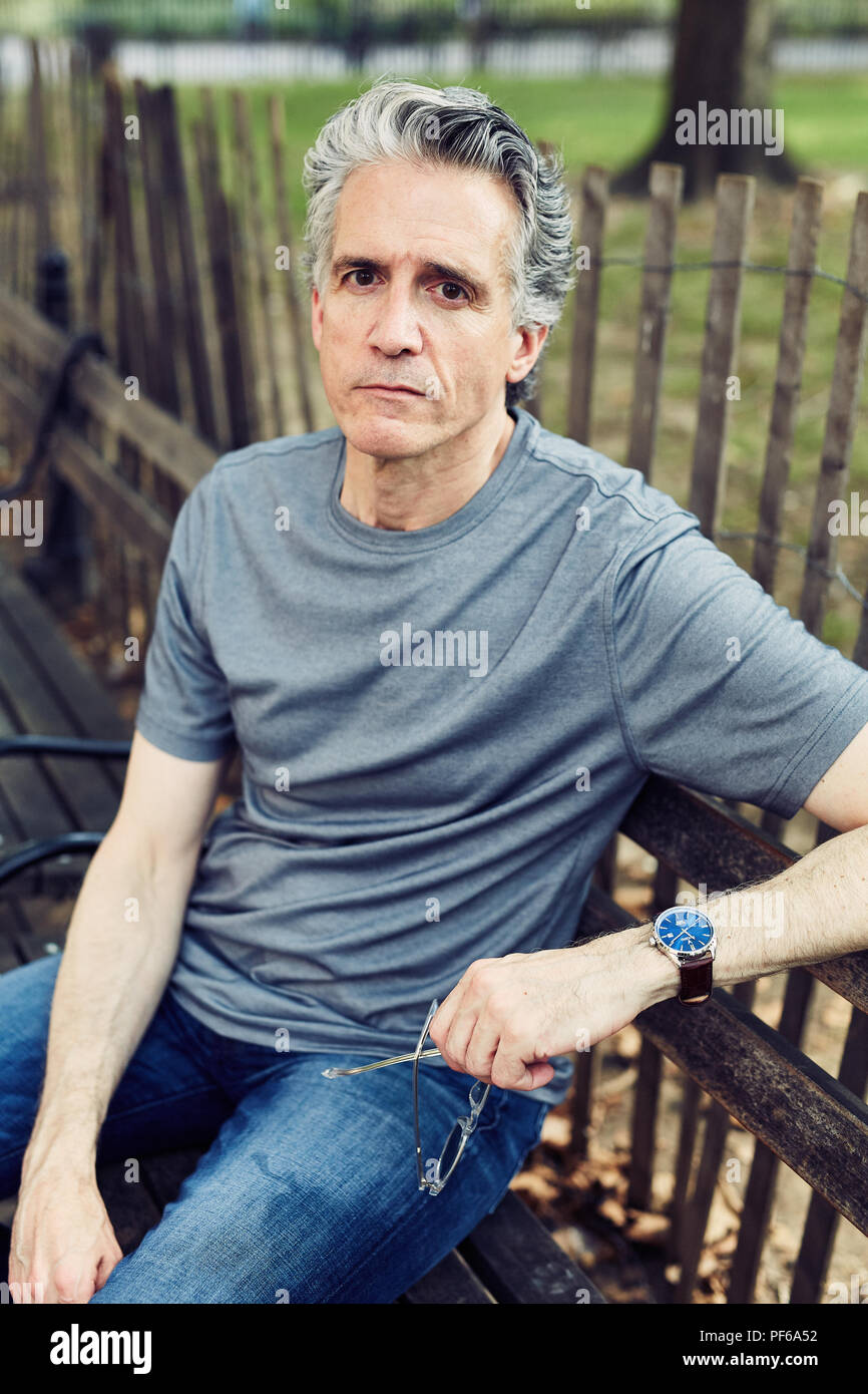 Grey Haired Man Sits on a Park Bench Stock Photo