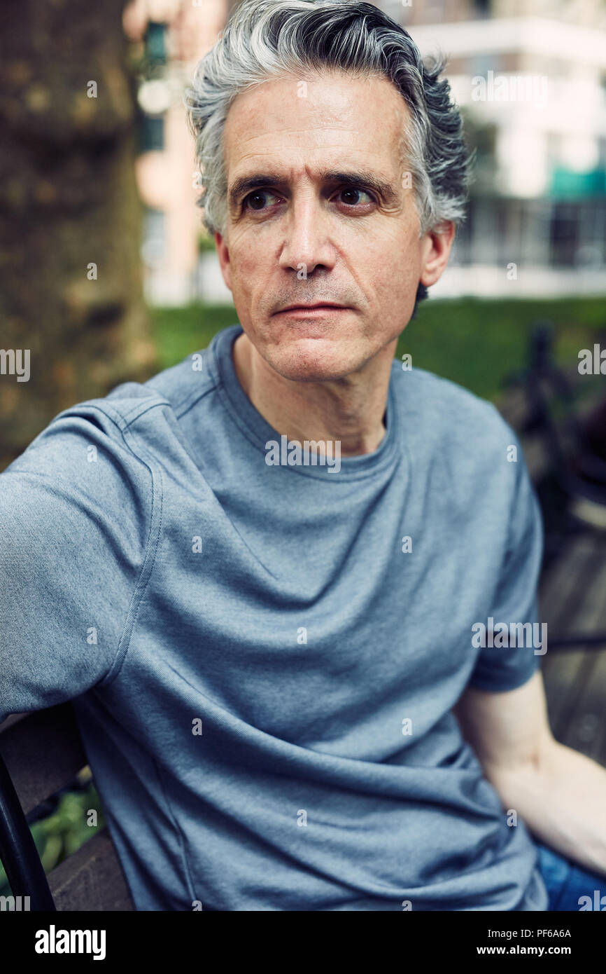 Grey Haired Man Sits on a Park Bench Stock Photo
