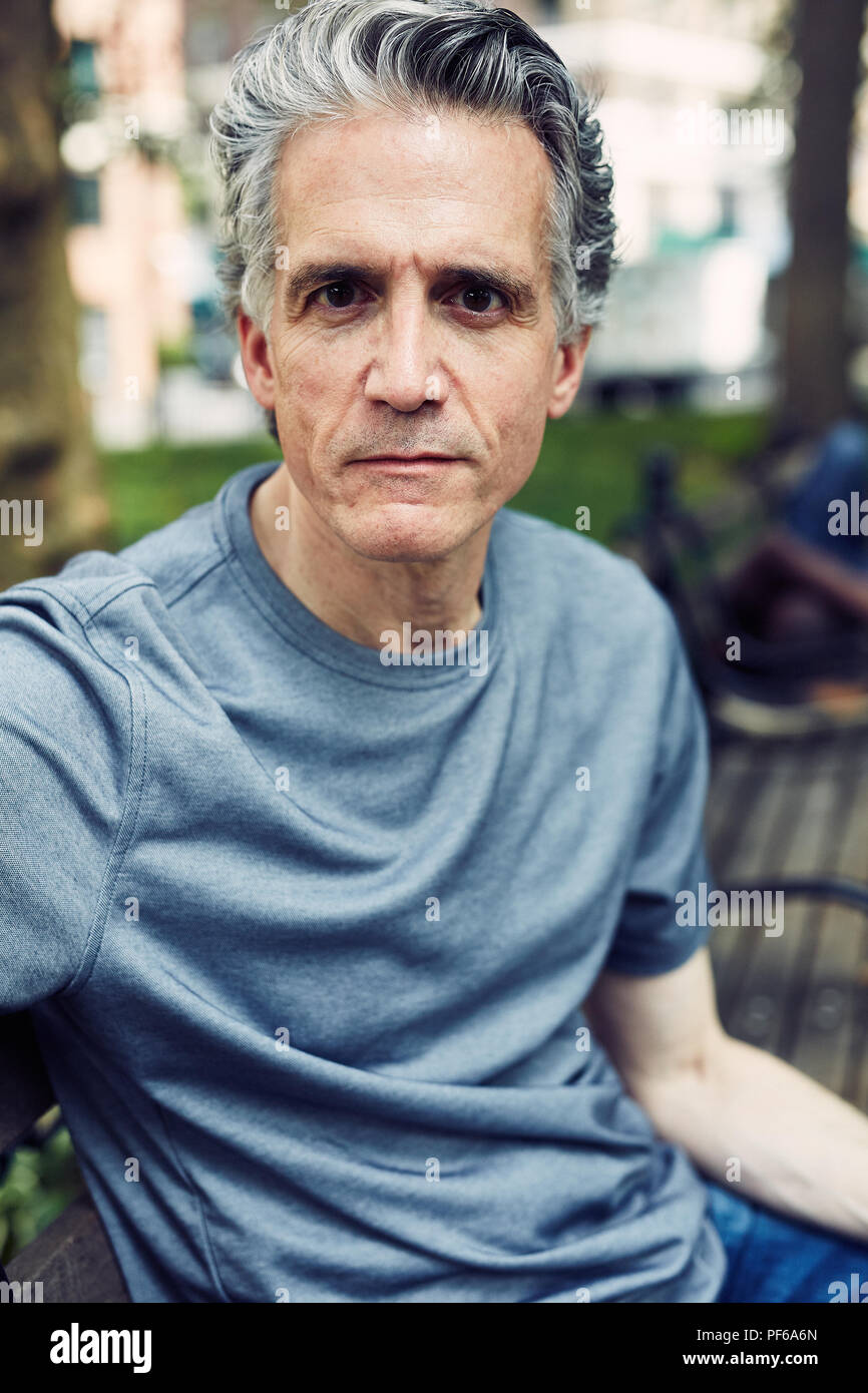 Grey Haired Man Sits on a Park Bench Stock Photo