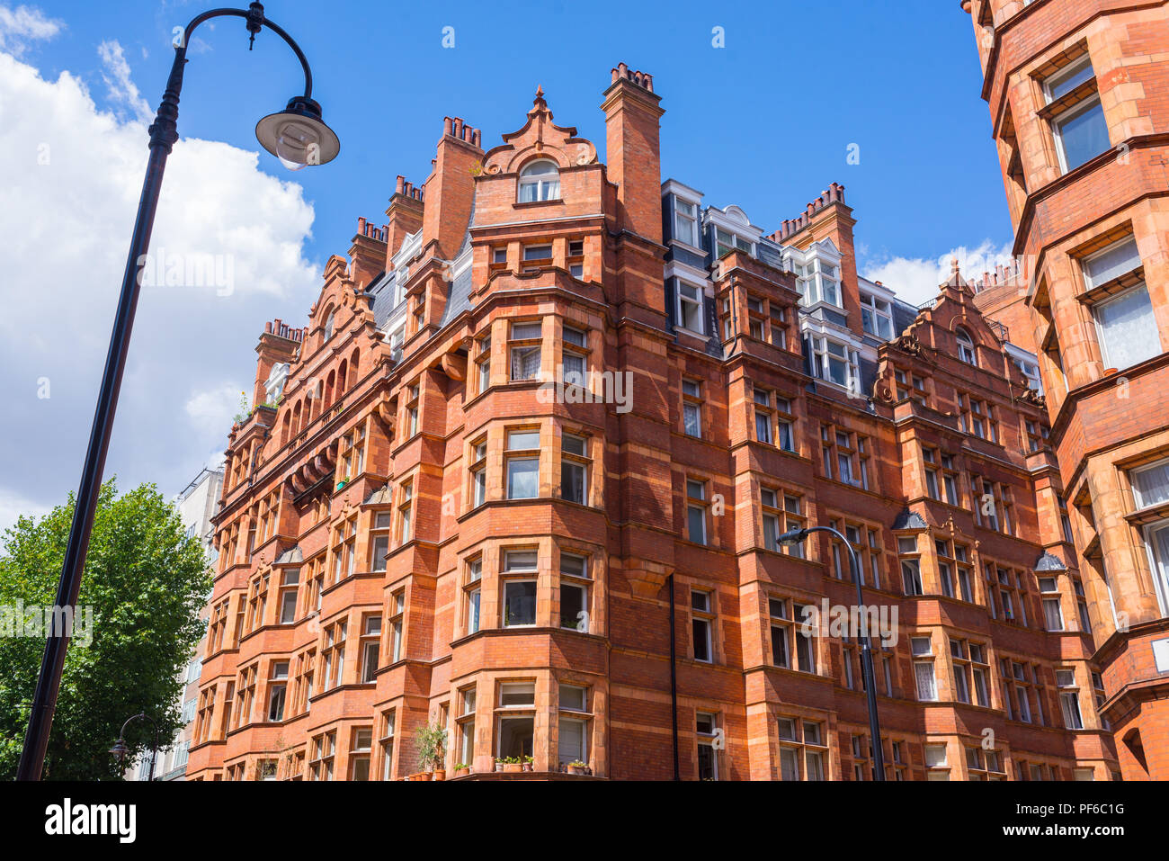 Opulent British Victorian terraced luxury residential apartments building in red bricks in Mayfair, London, UK Stock Photo