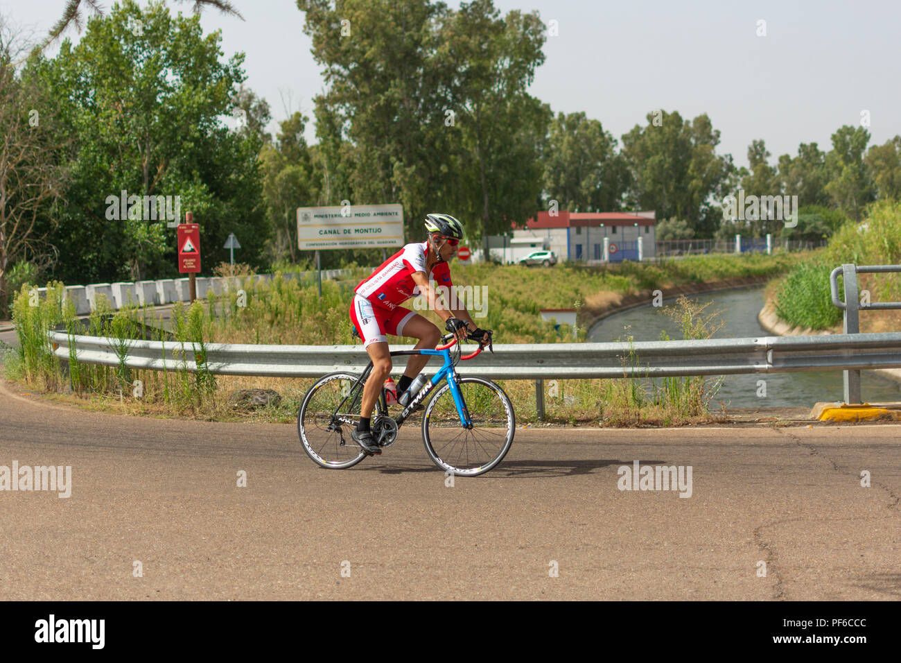 Bicycle rider passing through a highroad in Montijo, Extremadura, Spain. Stock Photo