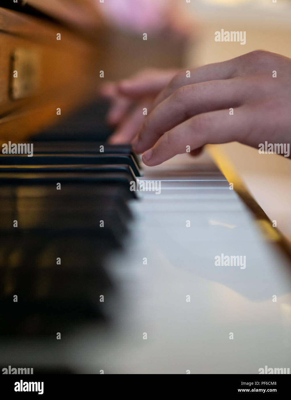 A young child who is an aspiring musician practices at the piano Stock