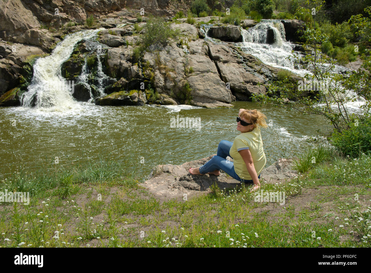 Zhitomir, Ukraine - July 16, 2018. The waterfall on the river flows through  and over the rocks covered with lichen and moss against a background of gr  Stock Photo - Alamy