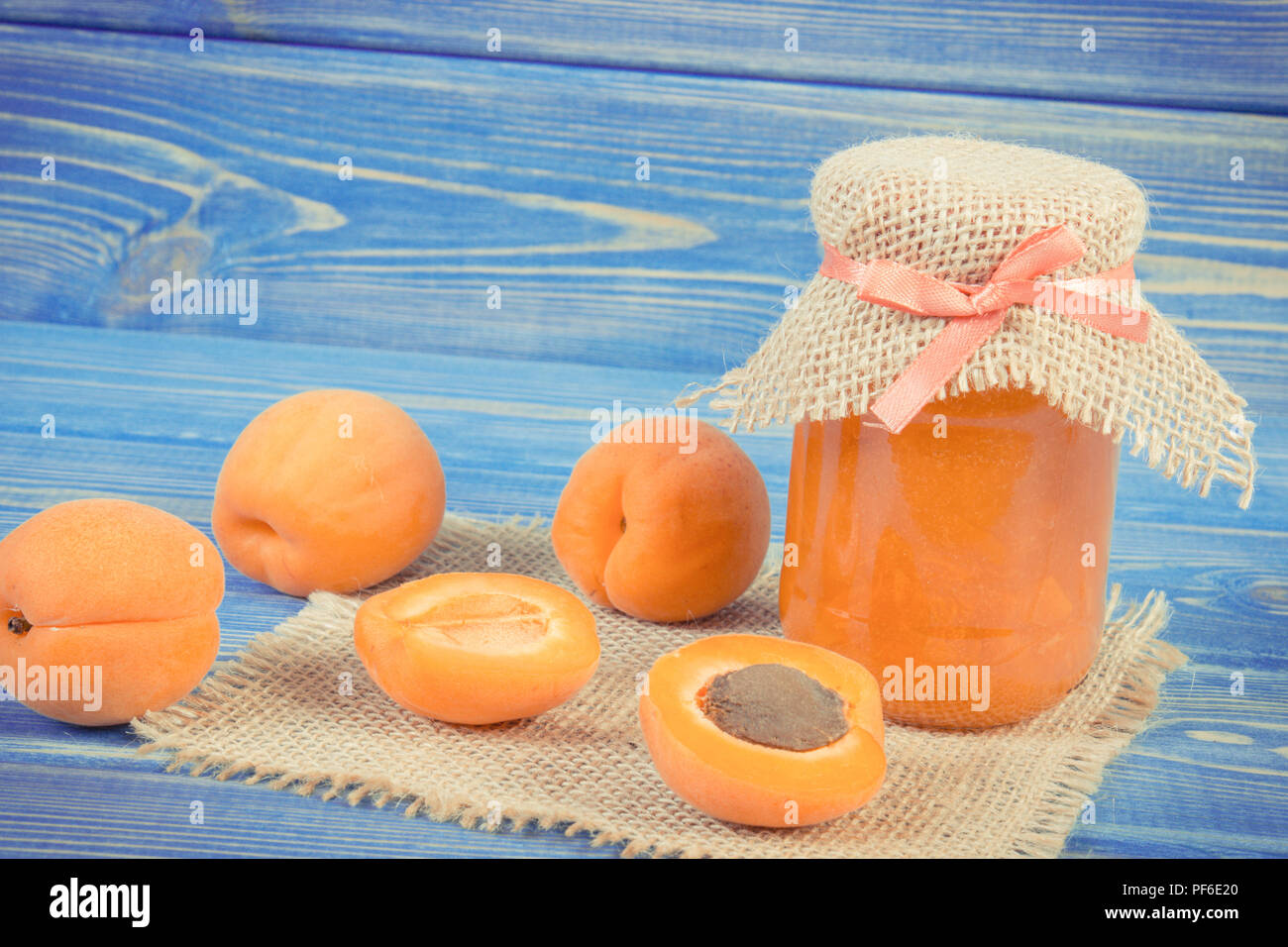 Fresh apricot jam or marmalade in glass jar and ripe fruits on boards, concept of healthy sweet dessert Stock Photo