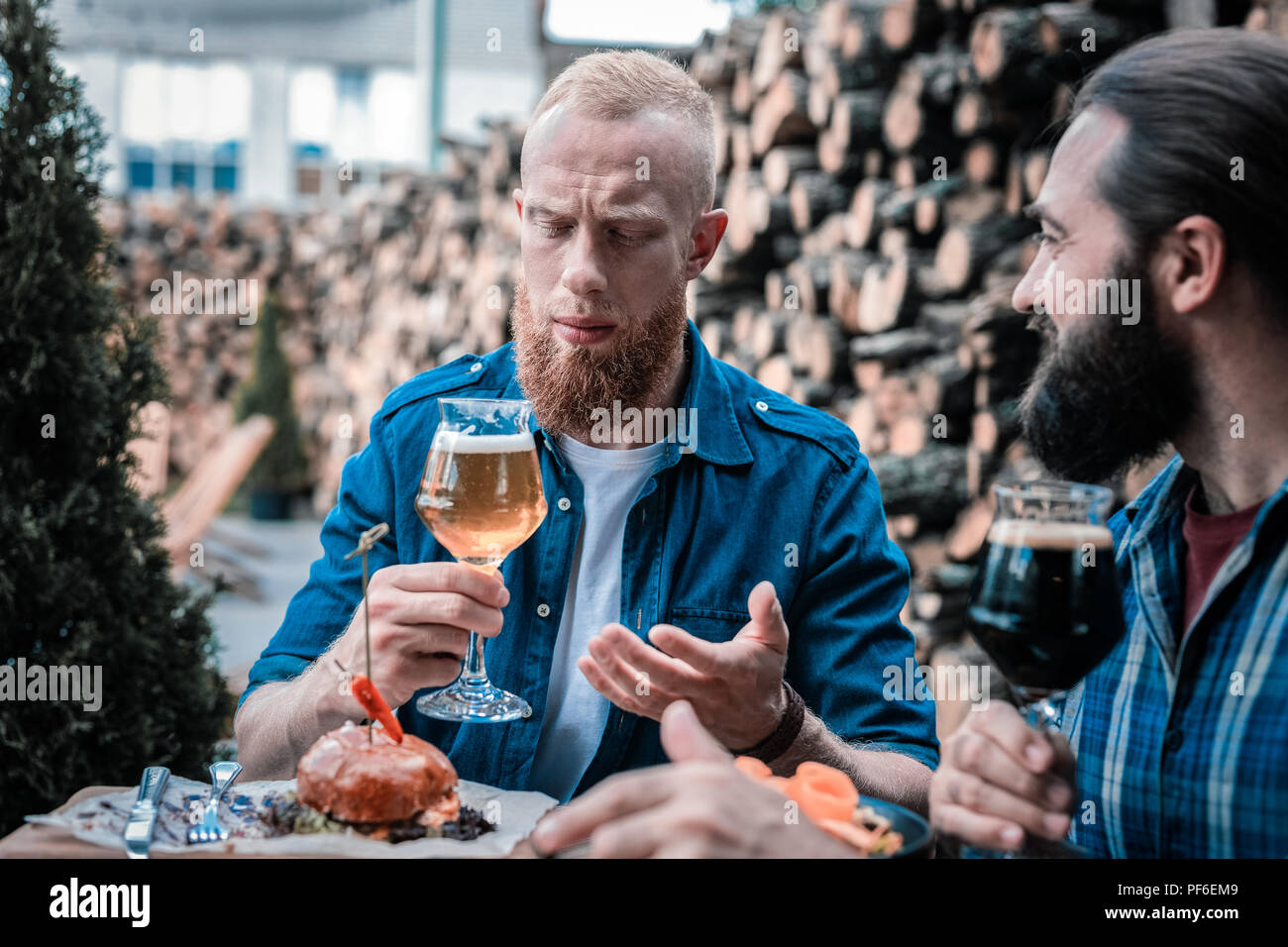 Red-haired man feeling strange after tasting light craft beer Stock Photo