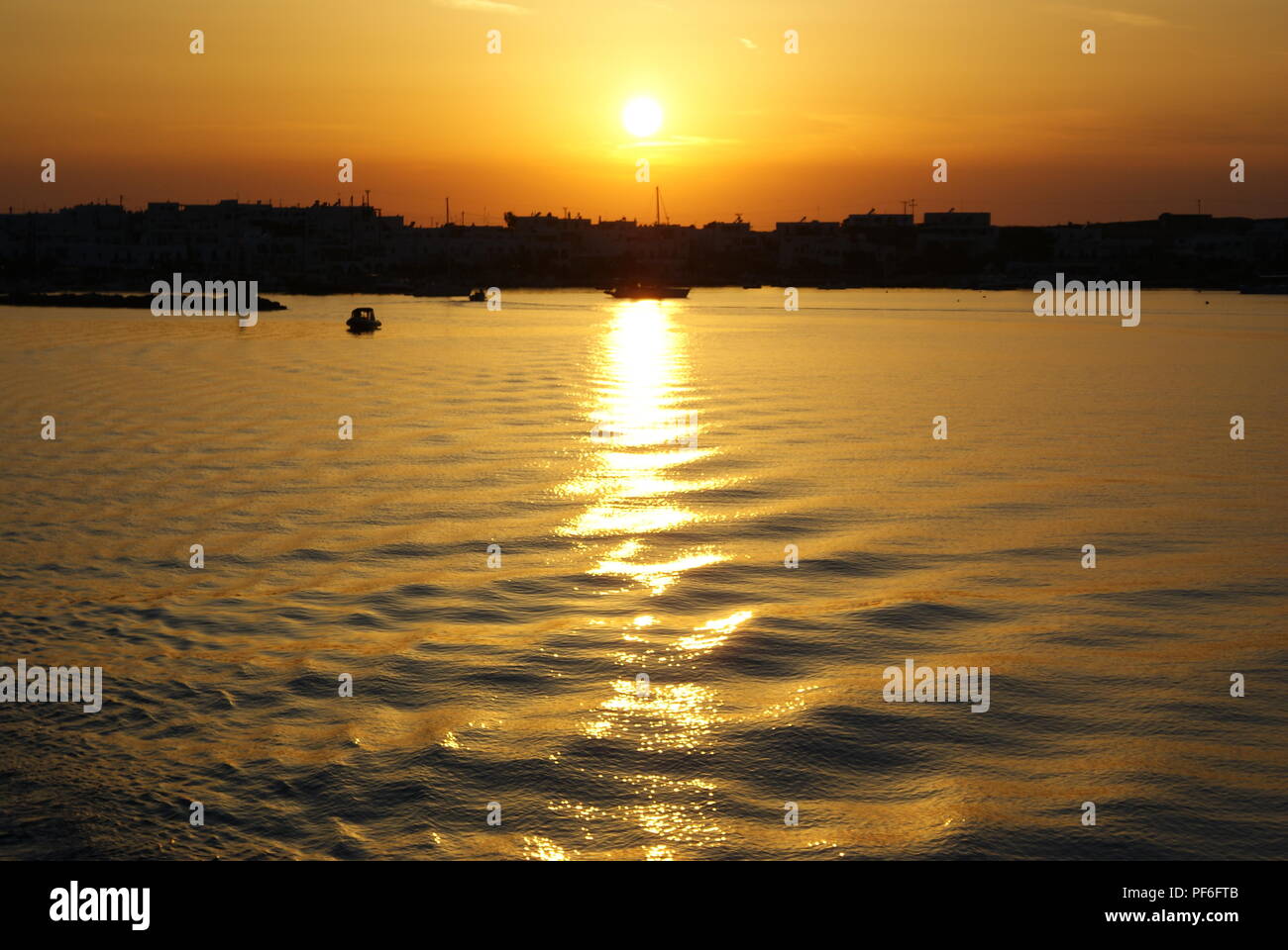 Greece, the island of Paros.  The sun sets over the neighboring island of Anti Paros Stock Photo