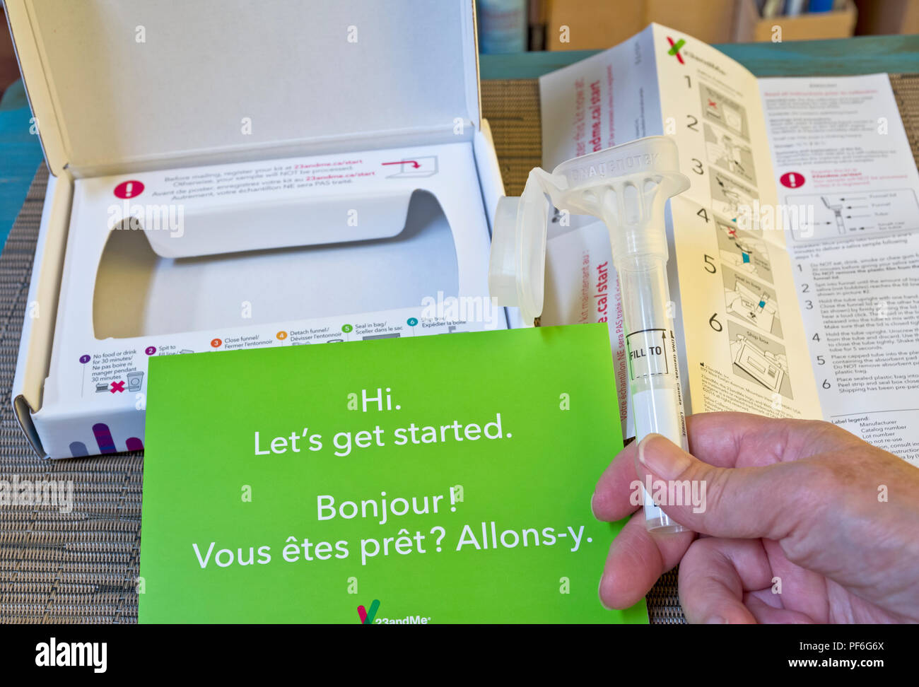 Hand holding 23andMe saliva collection home kit for DNA testing. Stock Photo