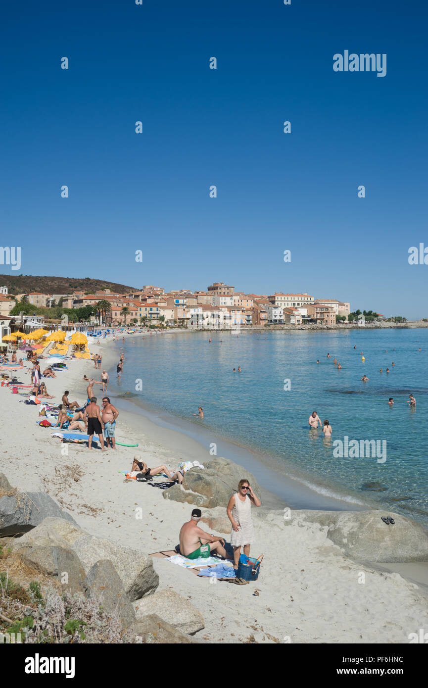 Tourists enjoying the sunshine on Plage du Napoleon beach, L'Île-Rousse, Corsica, France, Europe Stock Photo