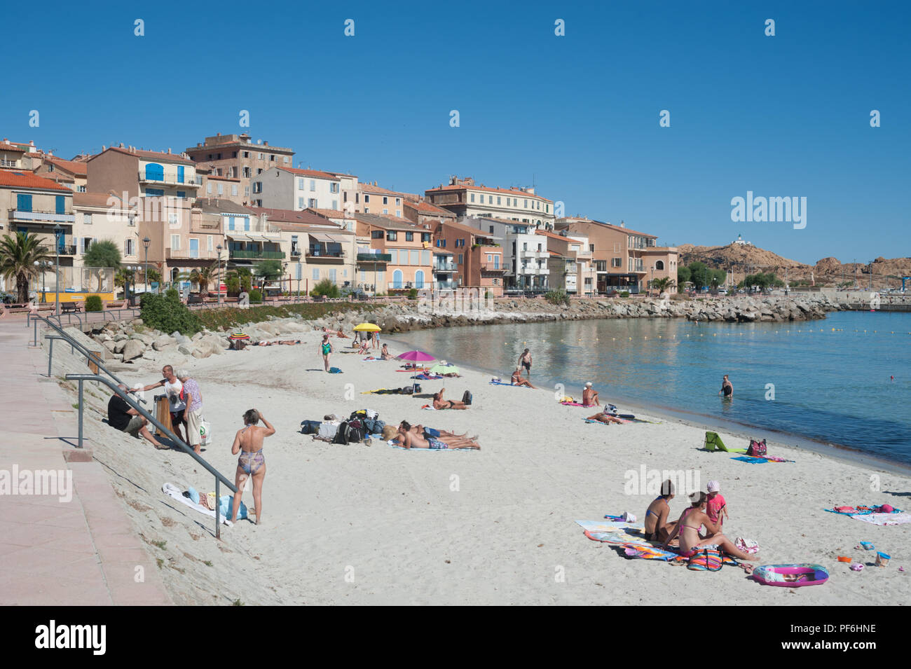 Tourists enjoying the sunshine on Plage du Napoleon beach, L'Île-Rousse, Corsica, France, Europe Stock Photo