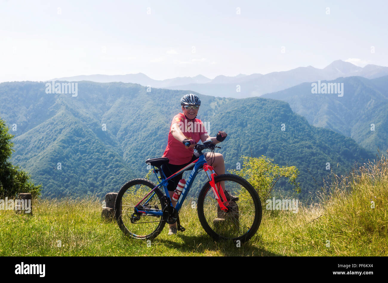 Smiling blonde woman cycling in the Mont Blanc mountains, France Stock Photo