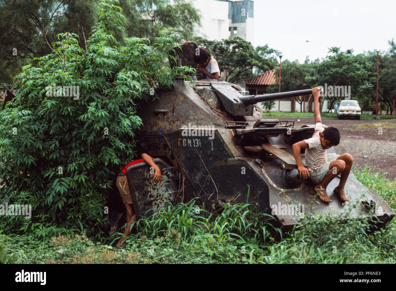 Managua, Nicaragua,  June 1986; Children play on the wrecked remains of Somoza's armoured tanks and APCs  in the centre of Managua. There were destryed by Sandinista forces in civil war against Somoza in 1979. Stock Photo