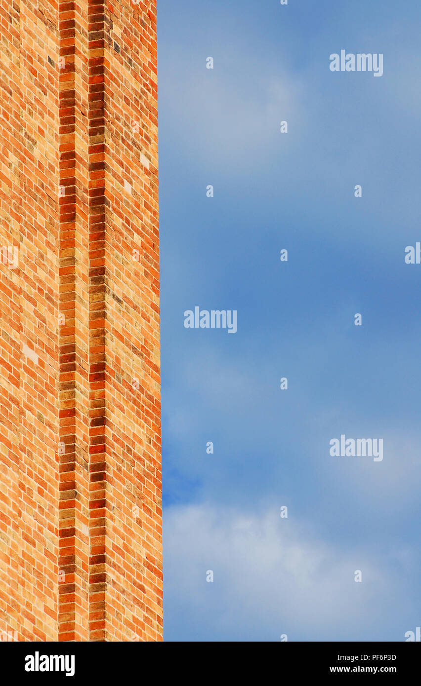 Red brick wall with cloudy sky as background Stock Photo