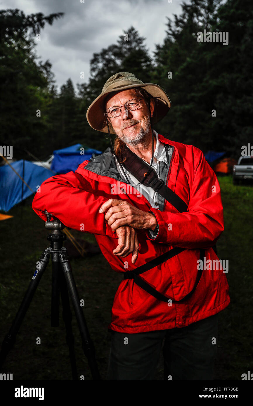 retrato del fotografo y biologo Chip Hedgcock recargado en su tripie. viste de sombrero, usa lentes e impermiable color rojo.    portrait of the photographer and biologist Chip Hedgcock recharged in his tripie. wear a hat, wear glasses and an impervious red color.  https://www.charleshedgcock.com  Charles 'Chip' Hedgcock has combined his love of the outdoors with more than 25 years of experience photographing in medicine, the life sciences, and fine arts, to create a unique vision of the natural world. Whether he is chasing fringe-toed lizards over remote sand dunes in the summer heat or, ligh Stock Photo